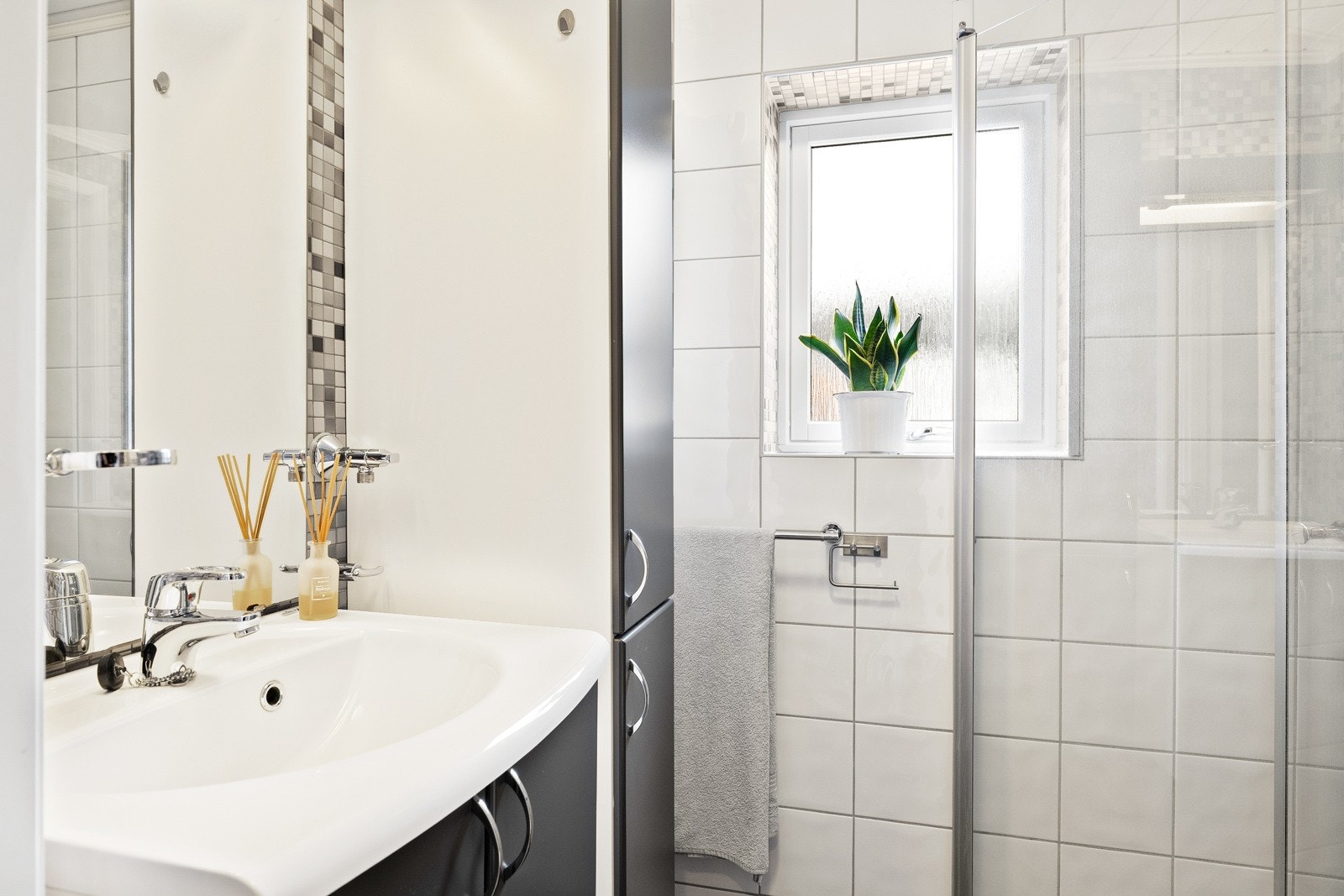 Badet har servantskap med tilknyttet speil, høyskap, dusjhjørne og vegghengt toalett. Opplegg for vaskemaskin. Galleribilde