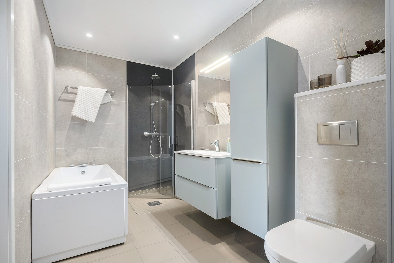 Badet er romsleg og flott. Her er det flislagt golv med varmekablar og downlights i himlinga. Galleribilde