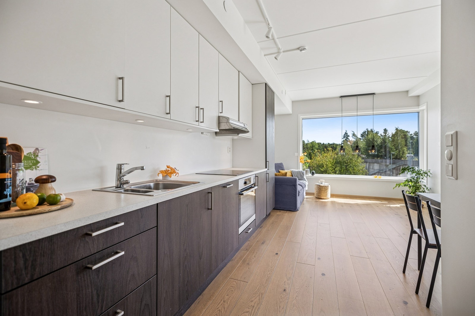 Pent og funksjonelt kjøkken med åpen løsning mot stue og spisestue, noe som skaper en sosial og luftig romfølelse. Galleribilde