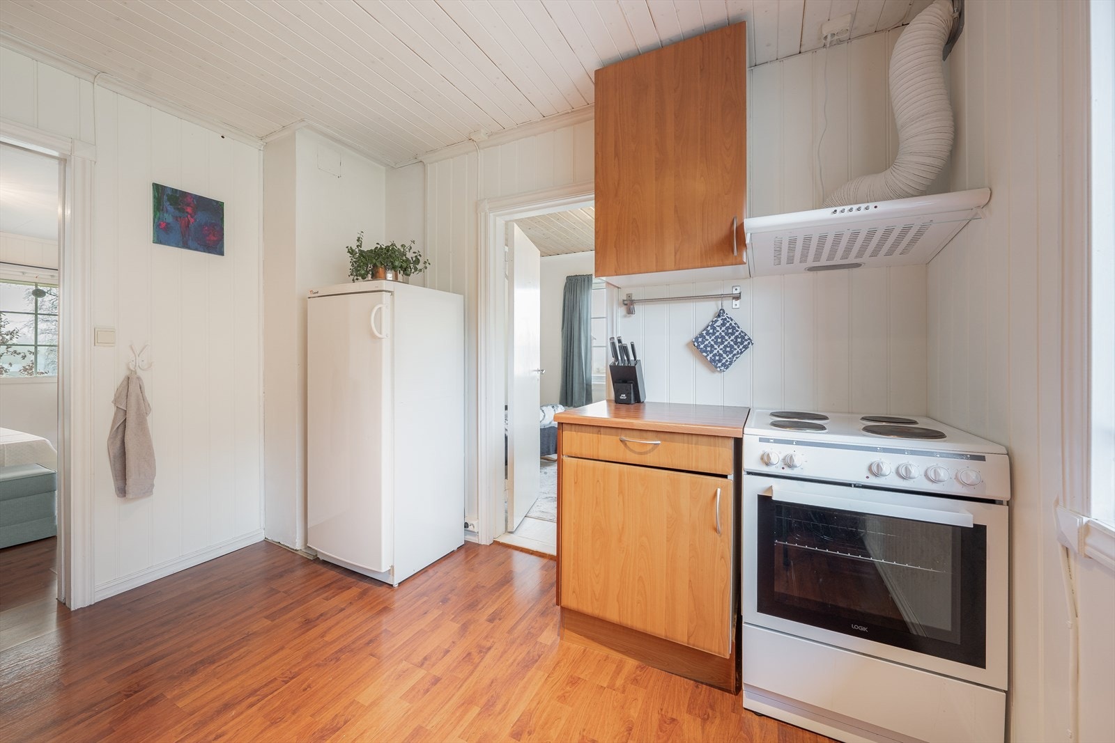 Laminat benkeplater med nedfelt oppvaskkum med to kummer og avrenningsflate. Opplegg og avsatt plass for frittstående hvitevarer for oppvaskmaskin, kjøleskap og komfyr. Galleribilde