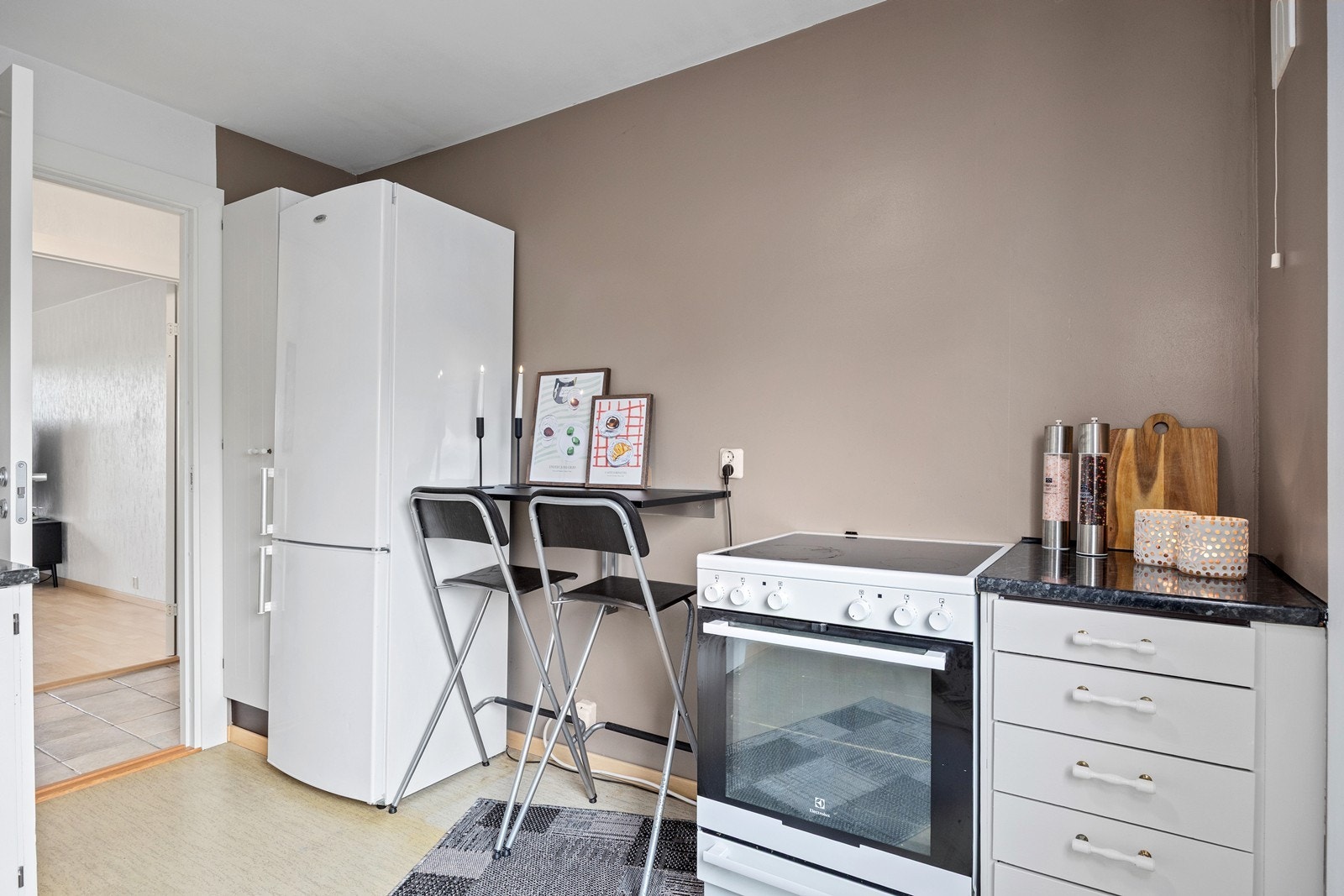 Det er laget en spiseplass for to ved den ene veggen. Det er ikke montert ventilator over komfyren, så det mangler mekanisk avtrekk fra kokesone i kjøkkenet Galleribilde