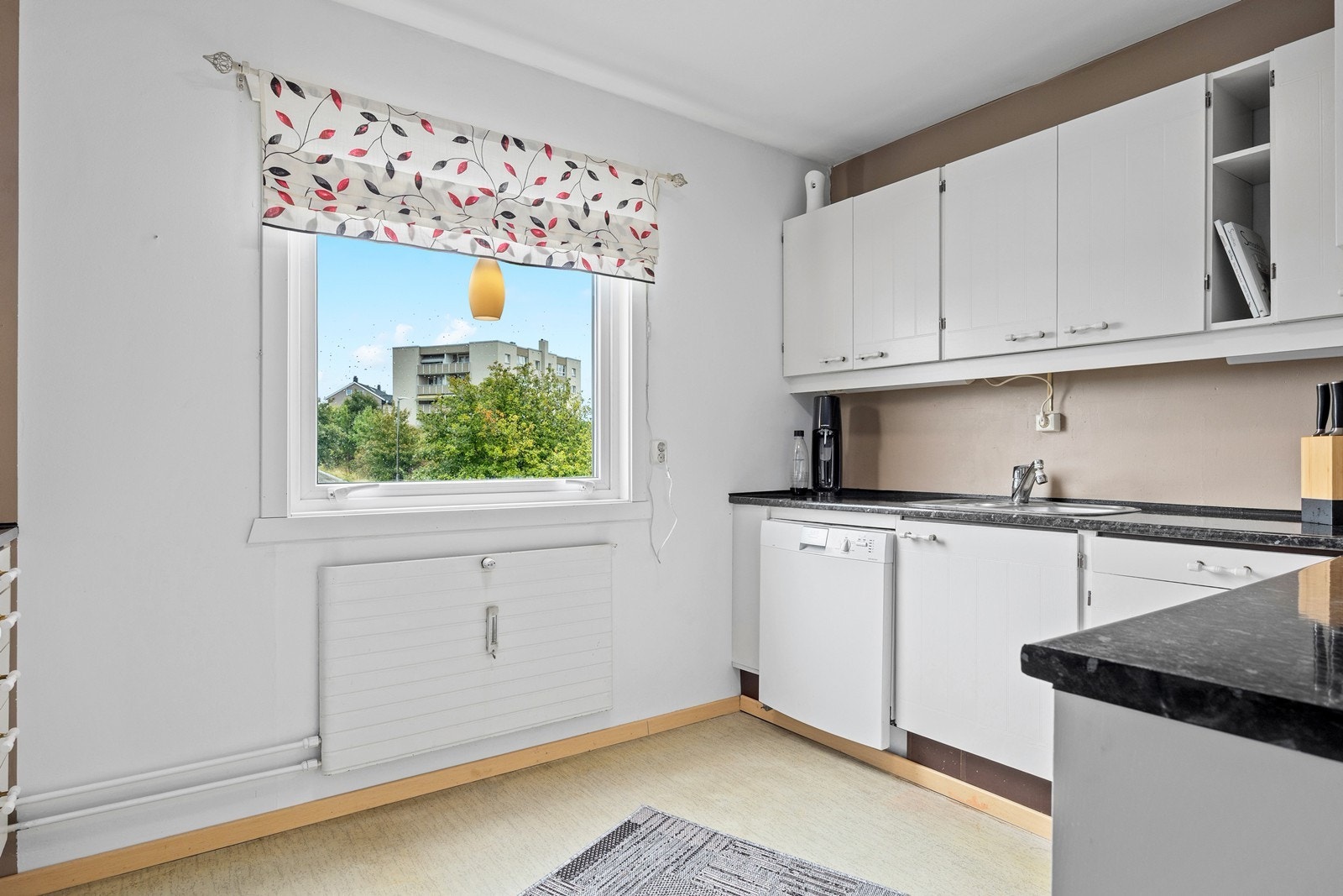 Separat kjøkken, med belegg på gulvet og malte flater på vegger og i himling. På kjøkkenet er det en eldre innredning med slette fronter, og med laminerte benkeplater Galleribilde