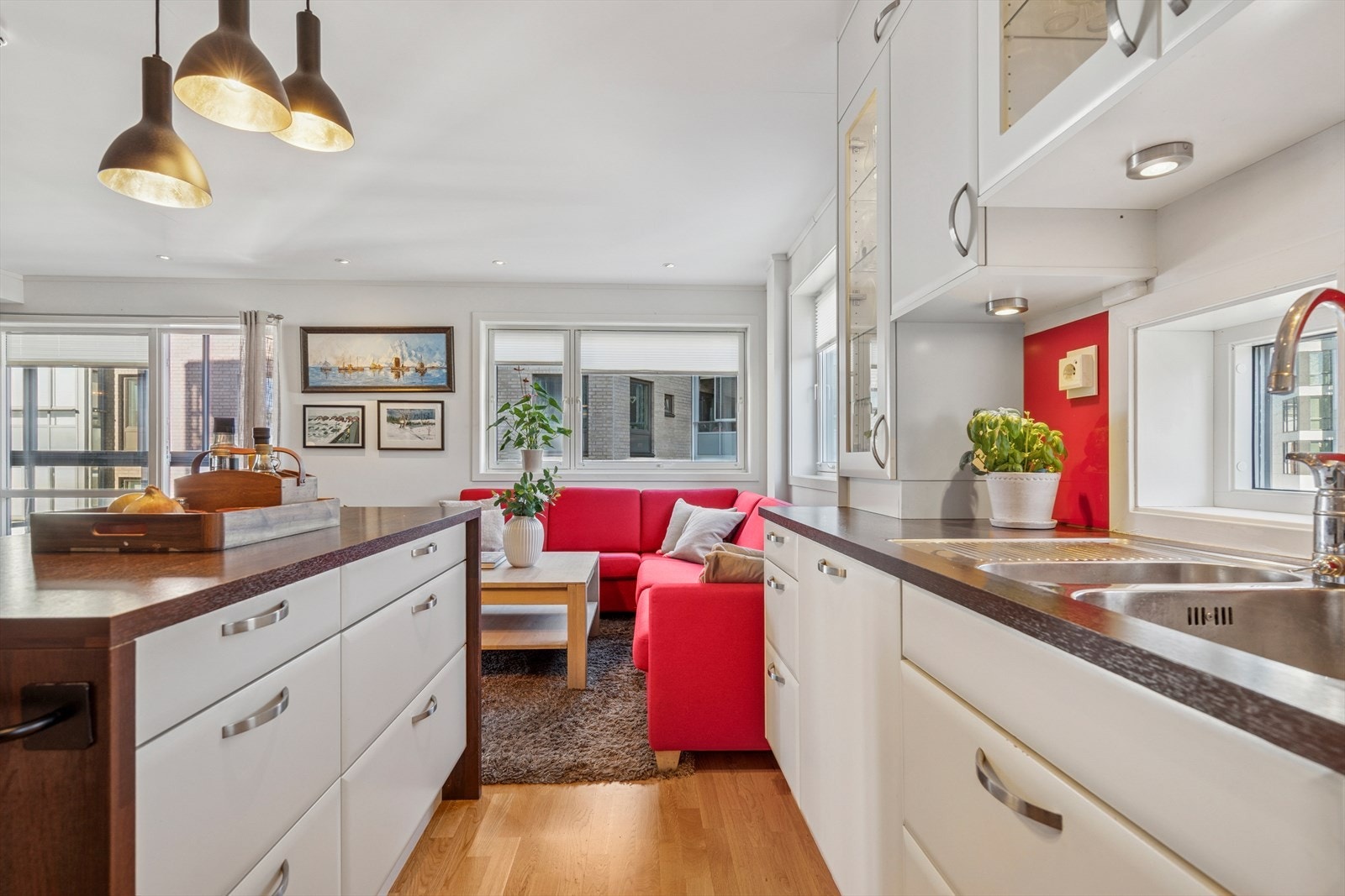 De røde detaljene tilfører en spennende kontrast og gir kjøkkenet karakter og personlighet. Laminat benkeplate med underlimt vask. Glassplate over benkeplate. Stekeovn skiftet i 2024, ellers er hvitevarene fra byggeår. Komfyrvakt. Galleribilde