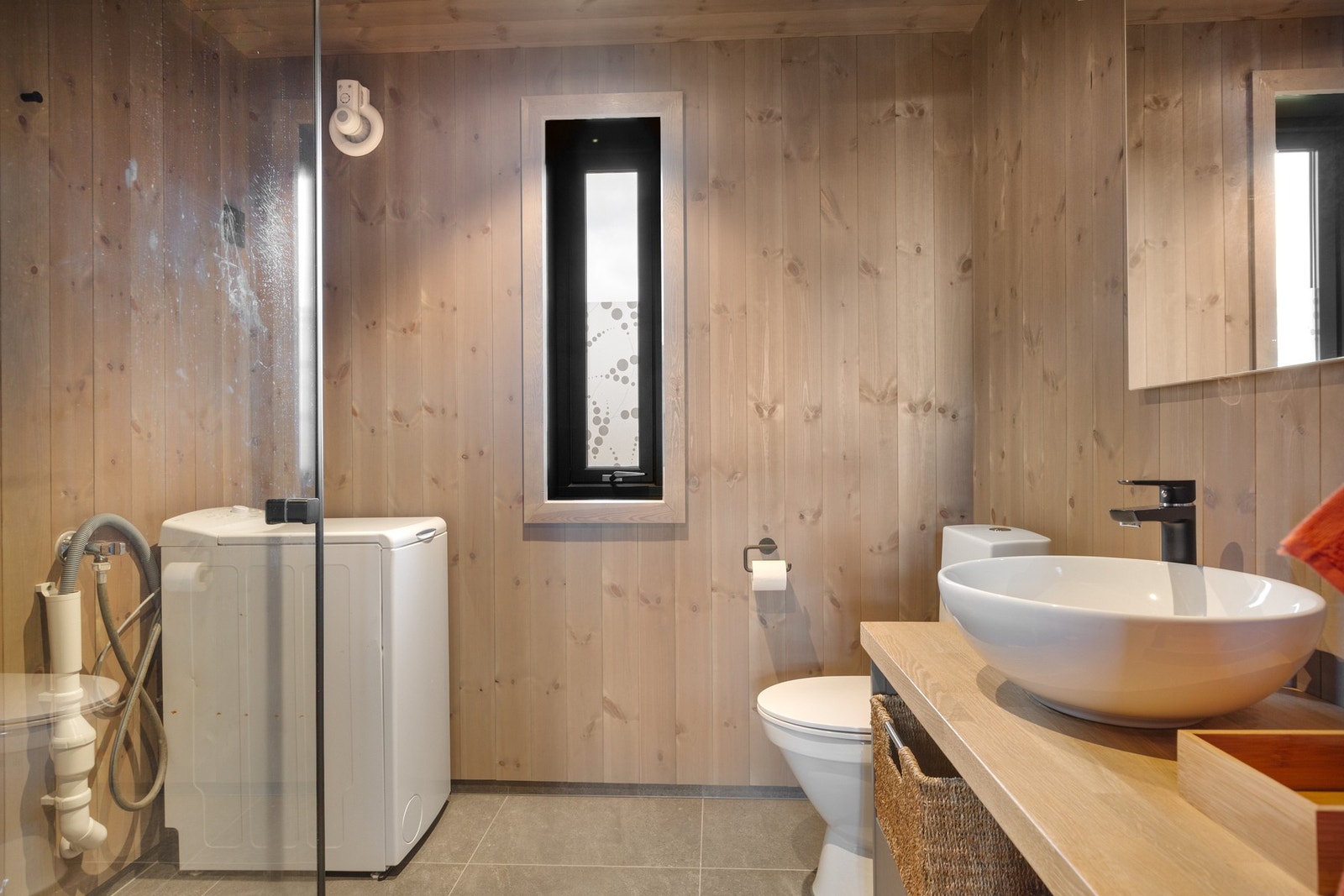 Bad 2 med servantinnredning, dusjdører, toalett og opplegg til vaskemaskin. Galleribilde