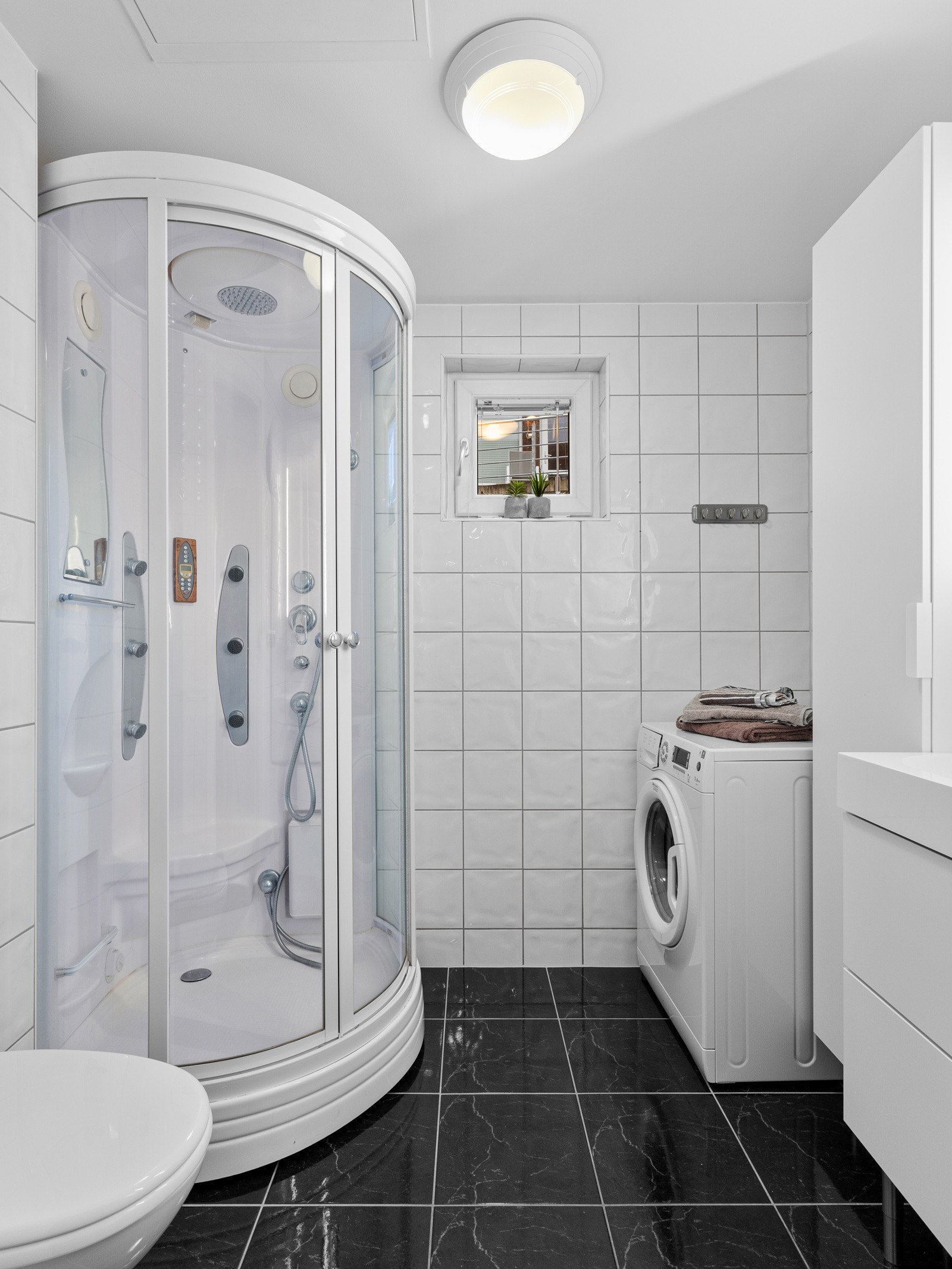 Bad/vaskerom med fliser på vegger og gulv Galleribilde