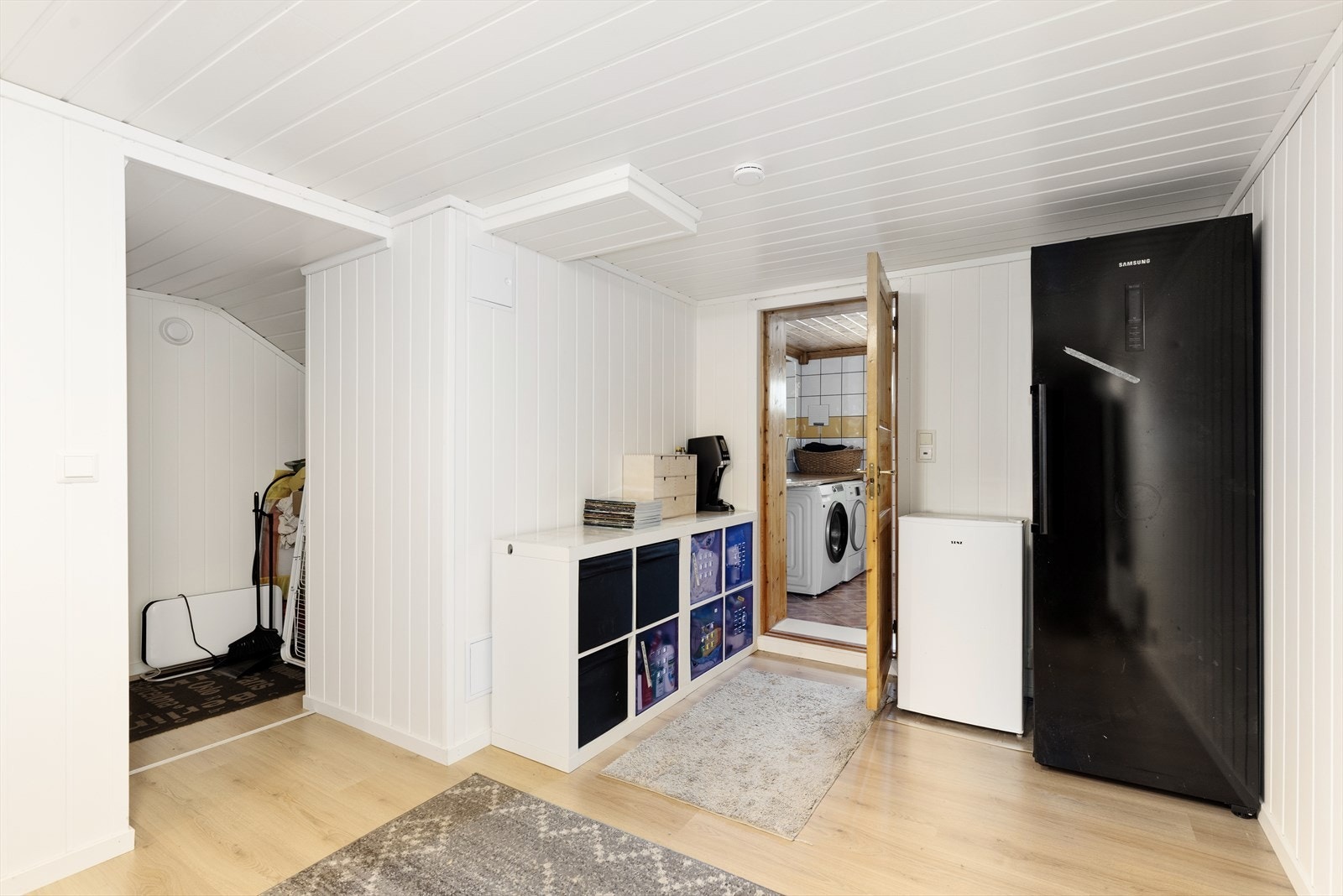 Liten entré med tilliggende trappegang i kjeller. Boligen har også et kombinert bad- og vaskerom i kjeller, med standard fra 2002. Galleribilde