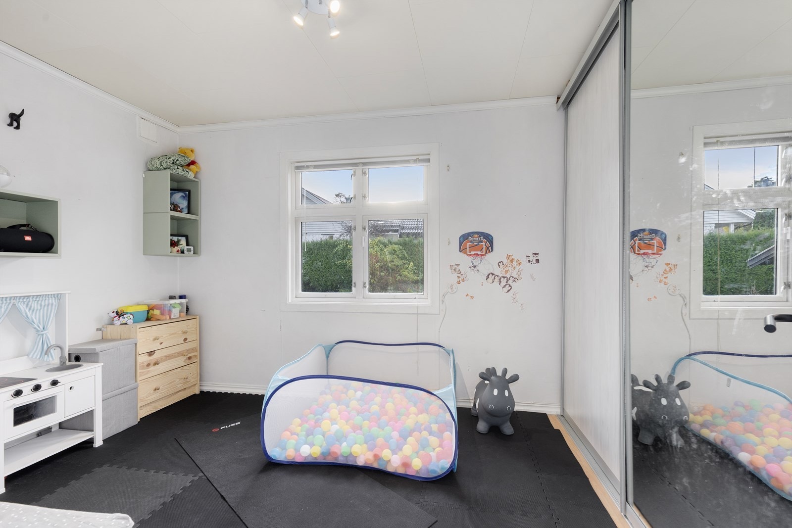 Soverommet i 1. etasje er lyst og romslig, med god plass til soveromsmøblement og praktisk skyvedørsgarderobe langs den ene veggen. Galleribilde