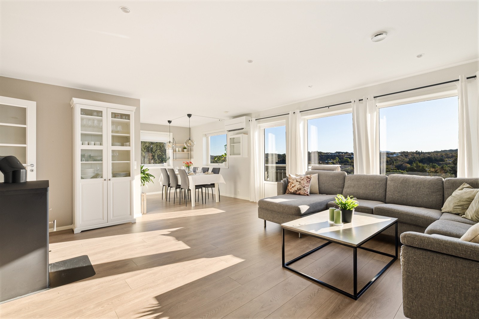 Den åpne, delvise løsningen mellom stue og kjøkken gir en fin romfølelse og en sosial sone der det er lett å samle familie og venner. Store vindusflater slipper inn rikelig med dagslys og skaper en luftig atmosfære. Galleribilde