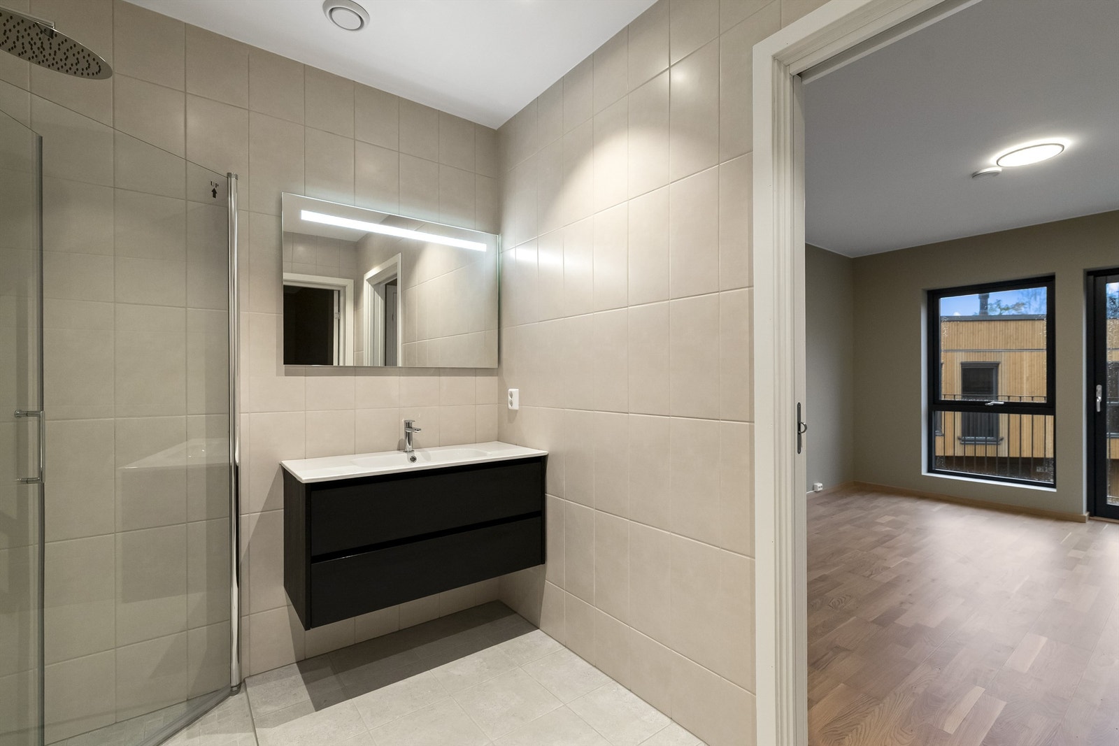 Flislagt bad med servant i innredning, dusjnisje og wc. Galleribilde