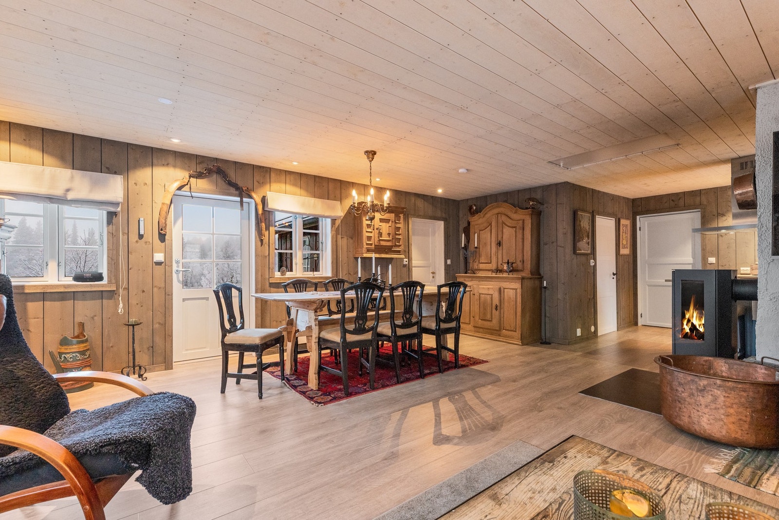 Stue og kjøkken i en delvis åpen løsning. Koselig peisovn gir god varme og lun stemning Galleribilde