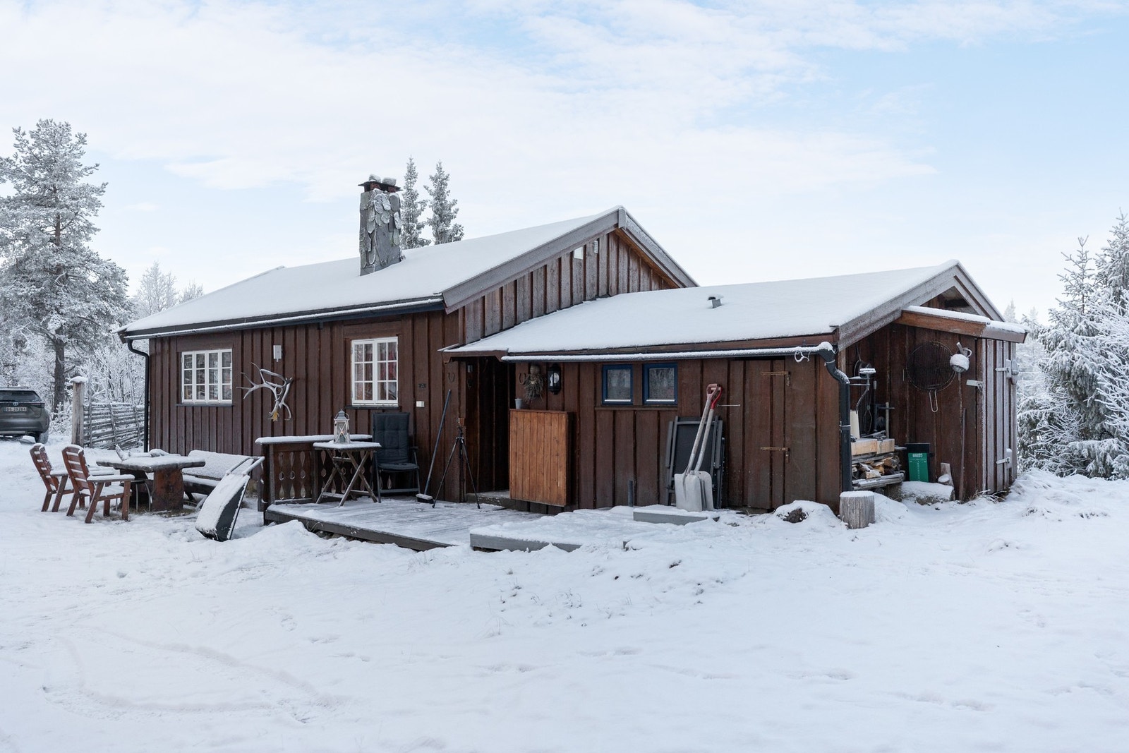 Her ser vi utvendig bod på en av hyttas kortsider, praktisk for oppbevaring av ved og utstyr Galleribilde
