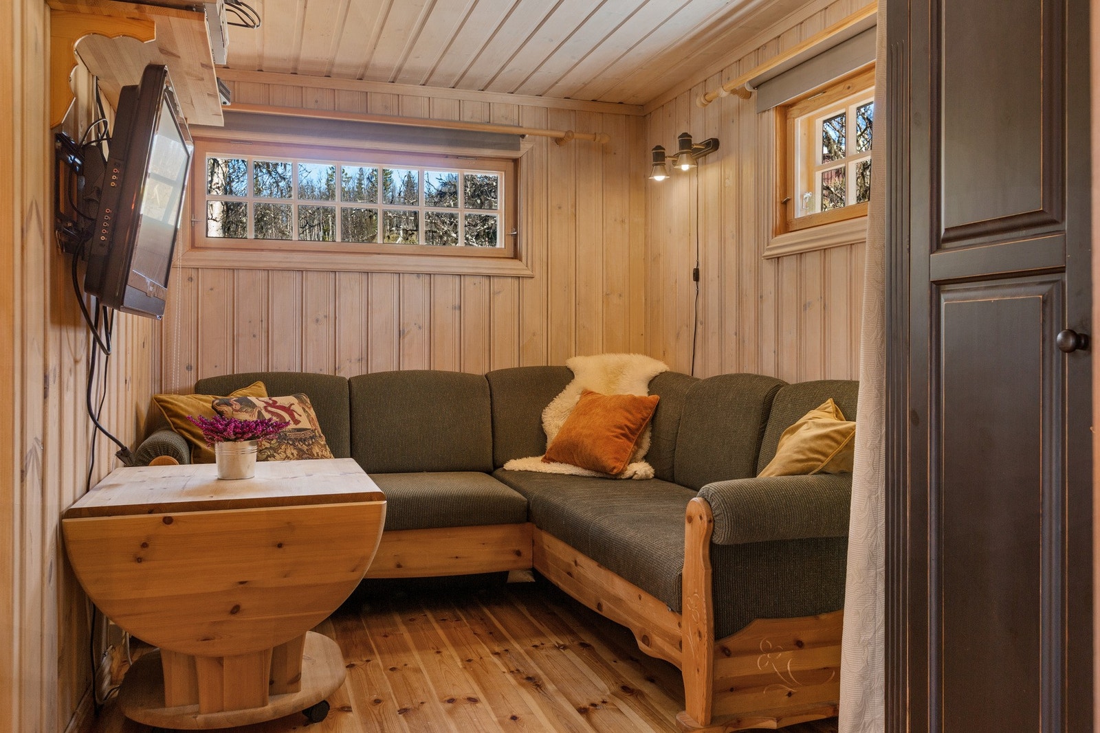 Litt adskilt fra stue/spisestue er det en egen tv-krok. Sofaen her er en sovesofa, bord kan trilles bort, og med forheng fungerer dette fint som et ekstra "soverom". Galleribilde