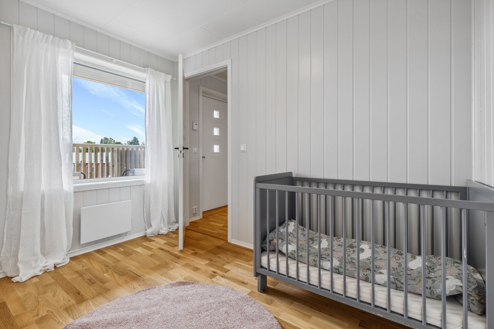 Soverom 2 fremstår som det perfekte ekstrarom - alt etter egne ønsker og behov. Rommet har lysmalt smartpanel på veggflater, trestavs parkett på gulv, garderobeskap og et stort vindu som slipper inn rikelig med lys. Galleribilde