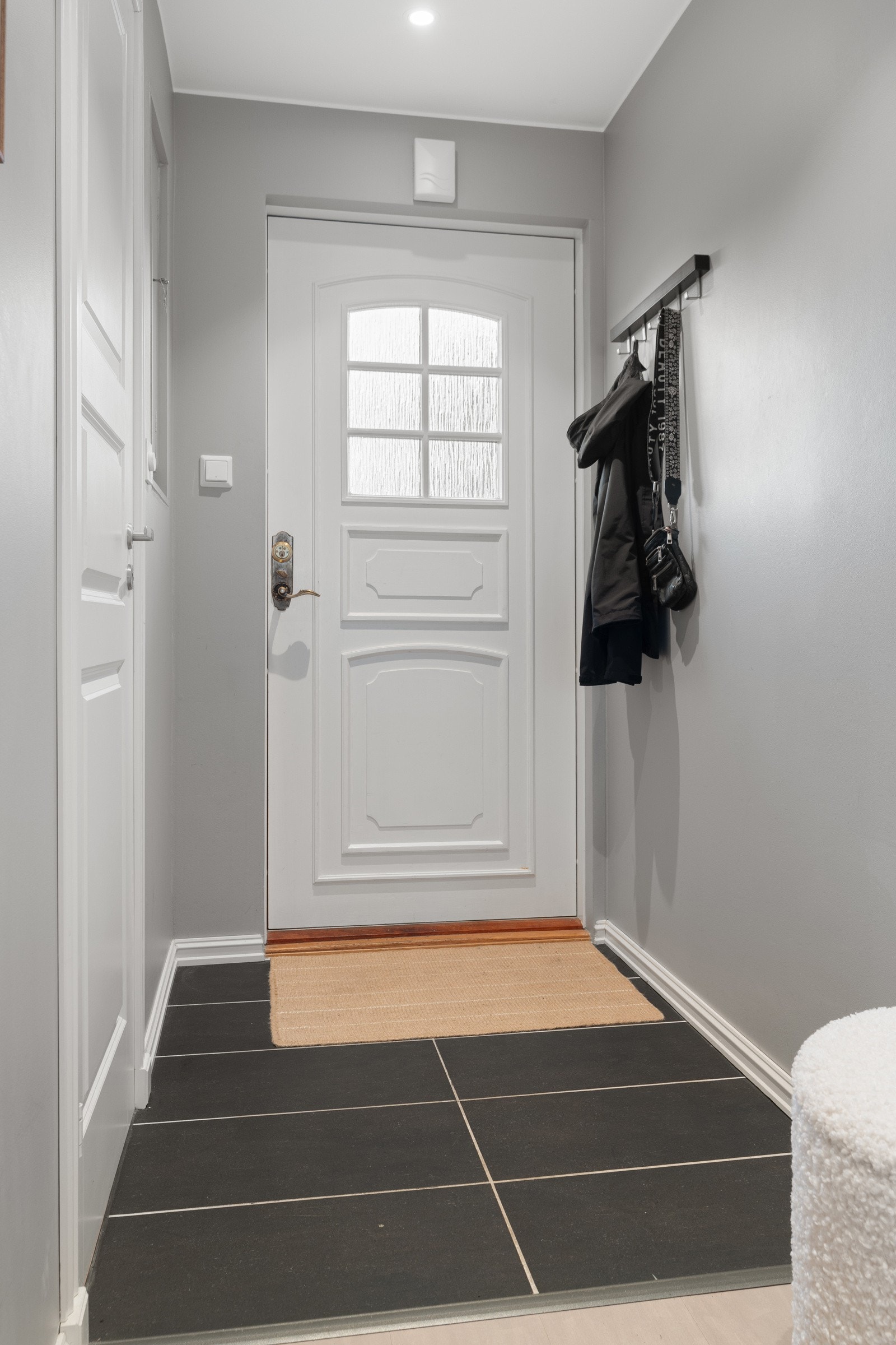 Flislagt yttergang med utgang til terrasse ved inngangsparti. Galleribilde