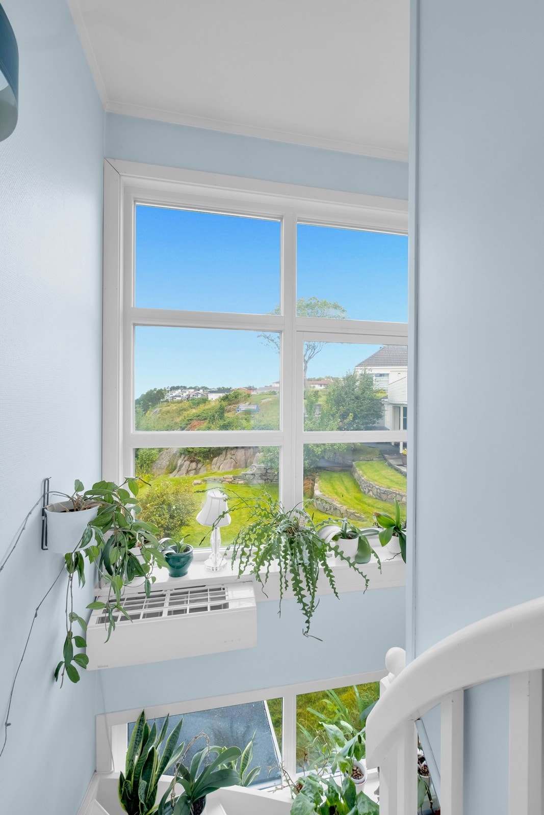 Store vinduer i trappeløpet slipper mye lys inn i boligen. Varmepumpe montert i trappeløpet. Galleribilde