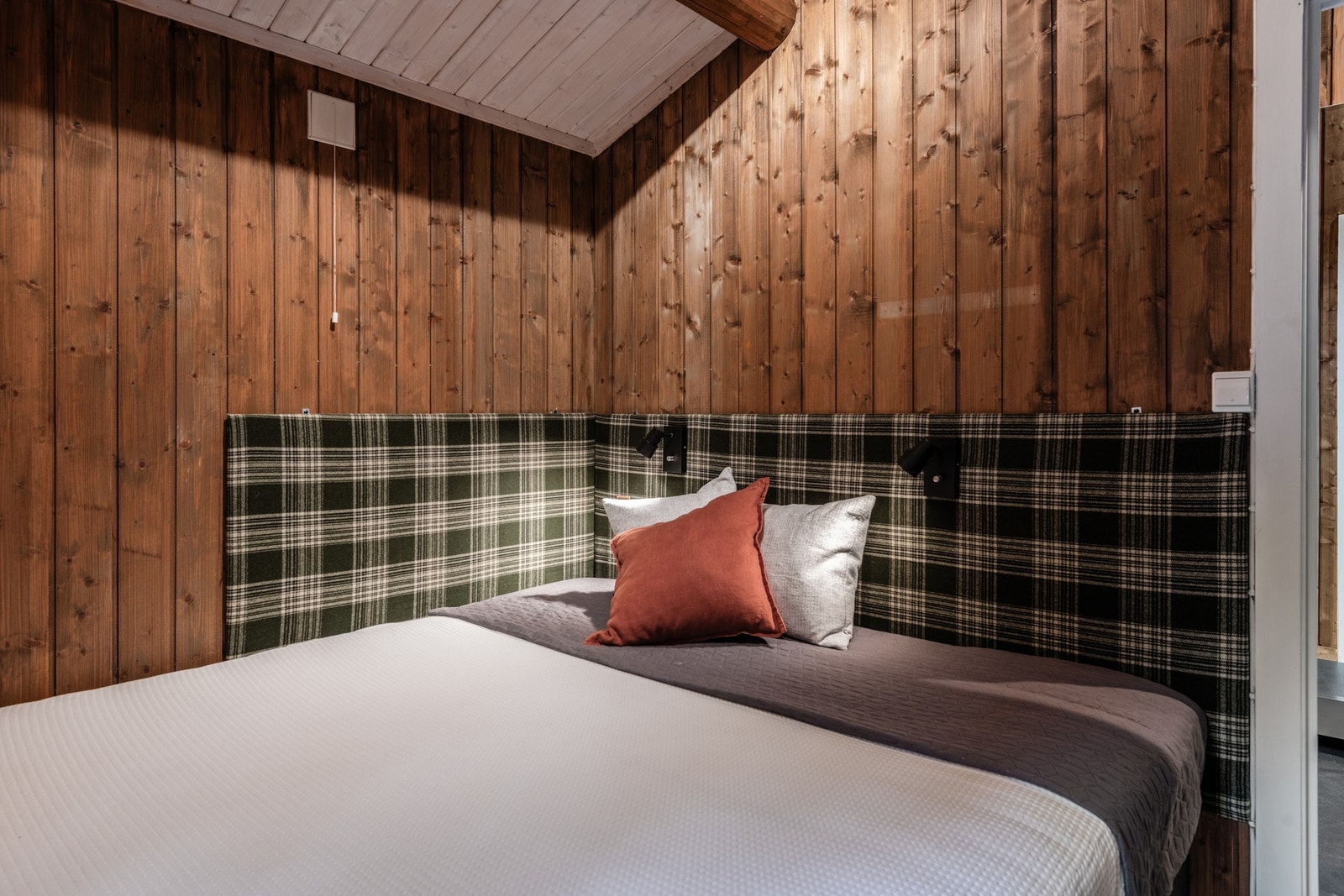 Praktisk "sengegavl"/putetrukket plate montert på vegg over seng gjør det behagelig og lunt. Galleribilde