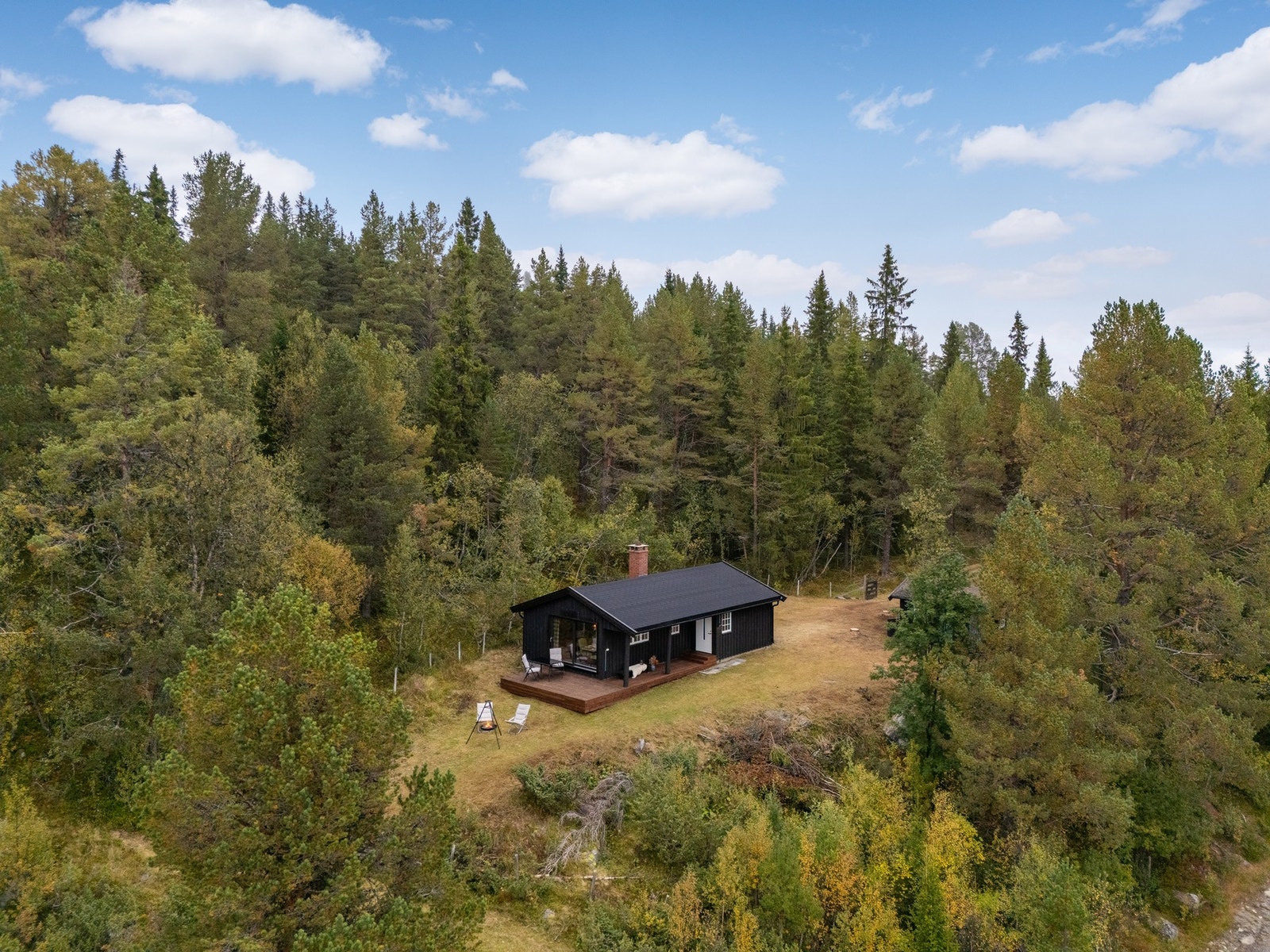 Tomten er fint opparbeidet rundt hytta med flere fine uteområdet hvor man kan sitte og nyte sol og utsikt Galleribilde