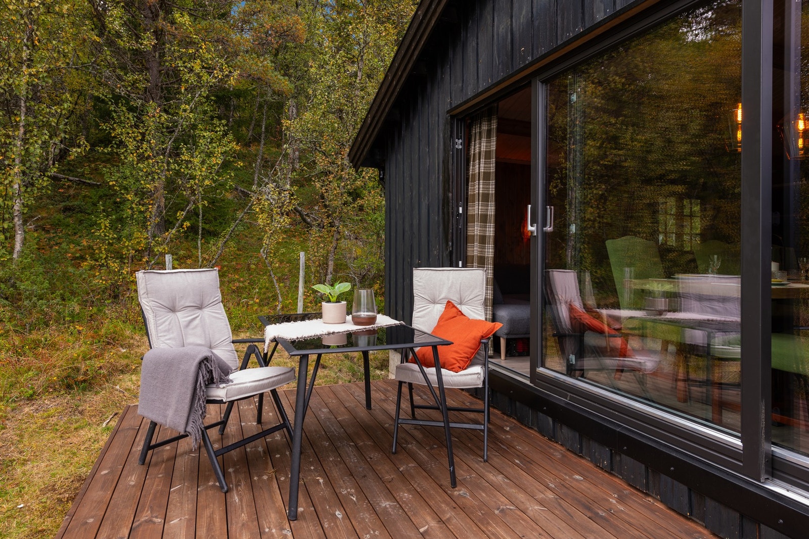 Store skyvedører ut til terrassen forlenger rommet på solfylte sommerdager Galleribilde