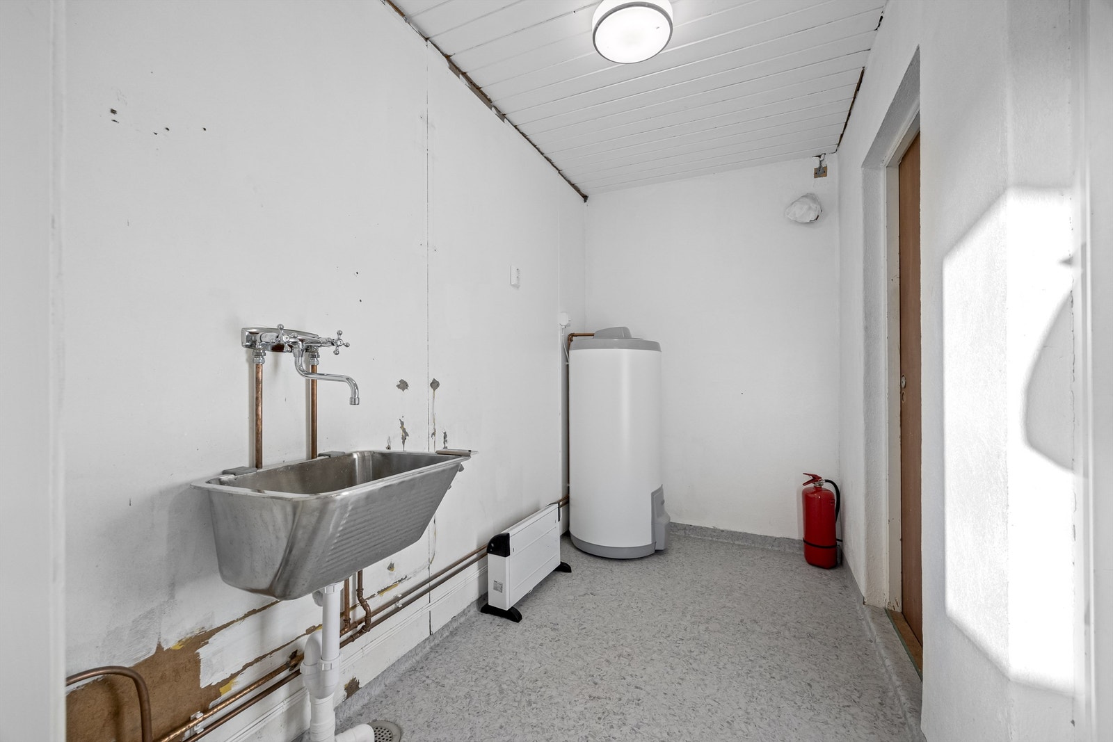 Vaskerom med nye rør til varmtvannstank, vask og vaskemaskin. Nyere varmtvannstank. Galleribilde