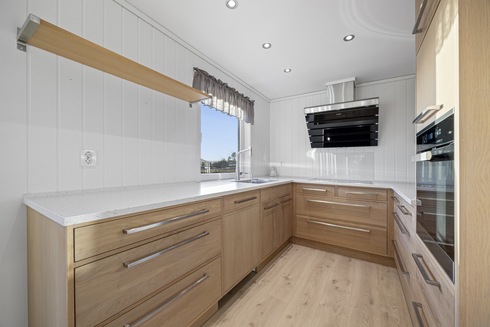 Integrerte hvitevarer og vifte på kjøkken er fra Miele. Galleribilde