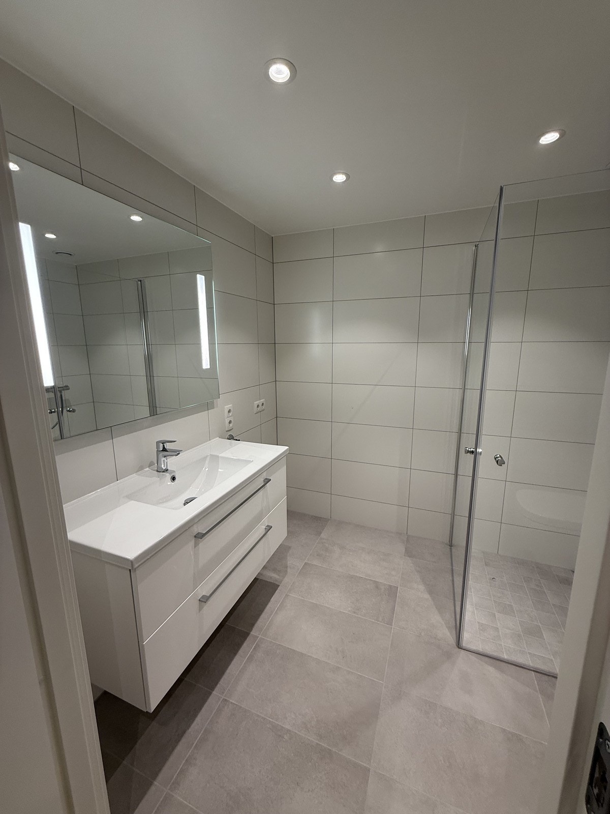 Pent flislagt bad med innfellbare dusjvegger og opplegg til vaskemaskin Galleribilde