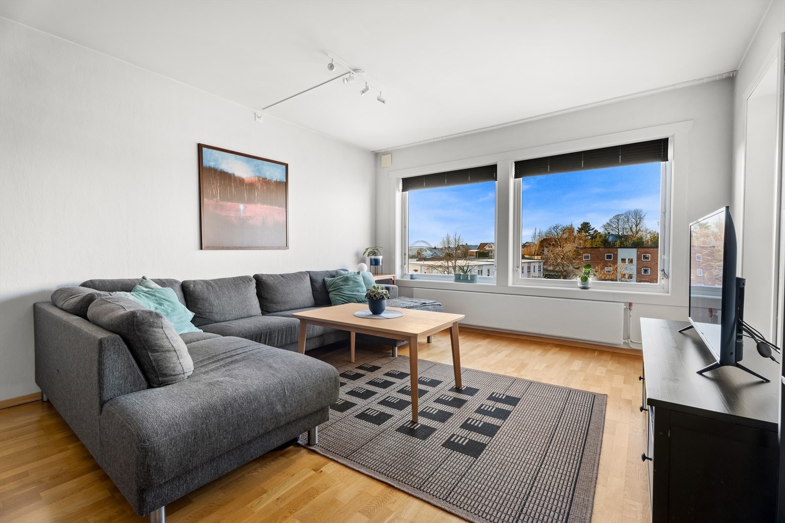 Leiligheten har en romslig stue med store glassflater som slipper inn rikelig med dagslys og bidrar til en behagelig romfølelse. Galleribilde