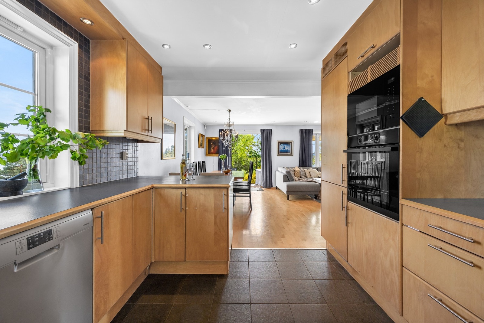 Kjøkken med integrerte hvitevarer og rikelig med skap- og benkplass Galleribilde