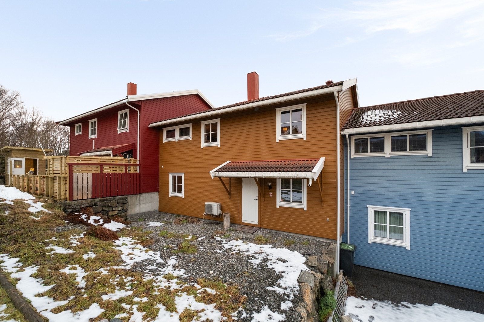 Fasade øst, med egen dør. Tomten opparbeidet med grus og noe plen. Galleribilde