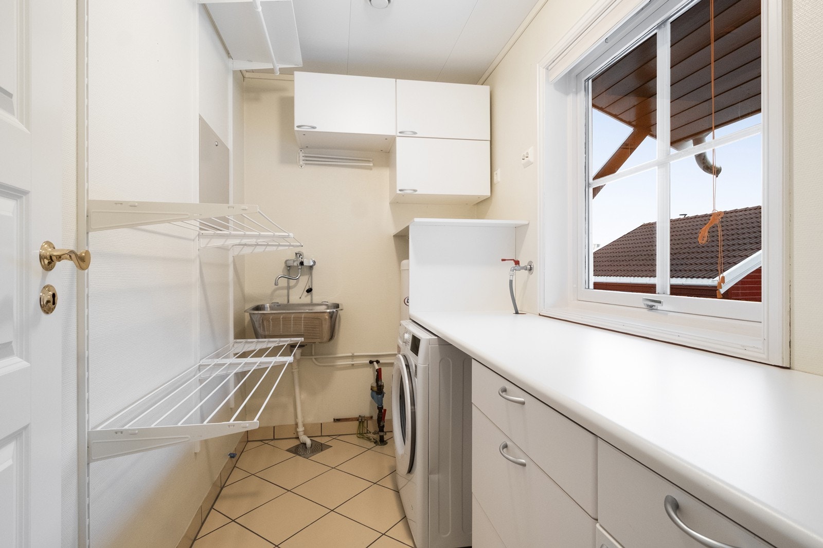 Boligen har også et eget vaskerom med lys innredning med glatte fronter og laminat benkeplate. Galleribilde