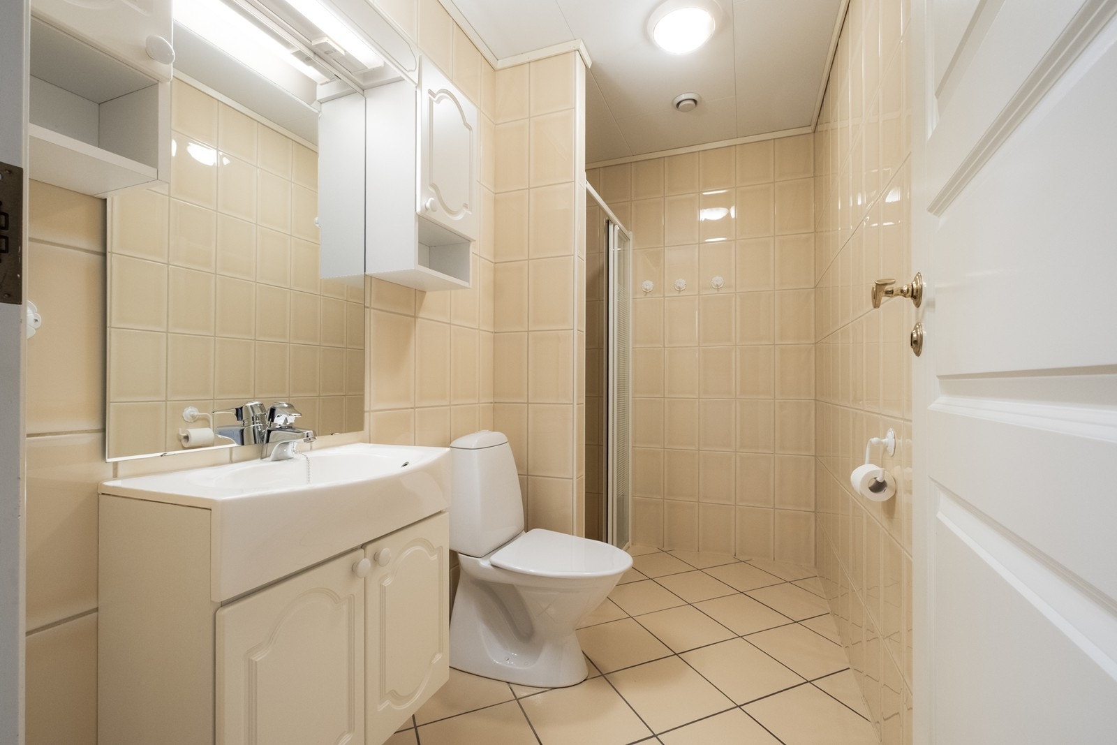 Flislagte bad i 1. etg. med elektriske varmekabler, dusjnisje, toalett og en servant med en liten baderomsinnredning. Galleribilde