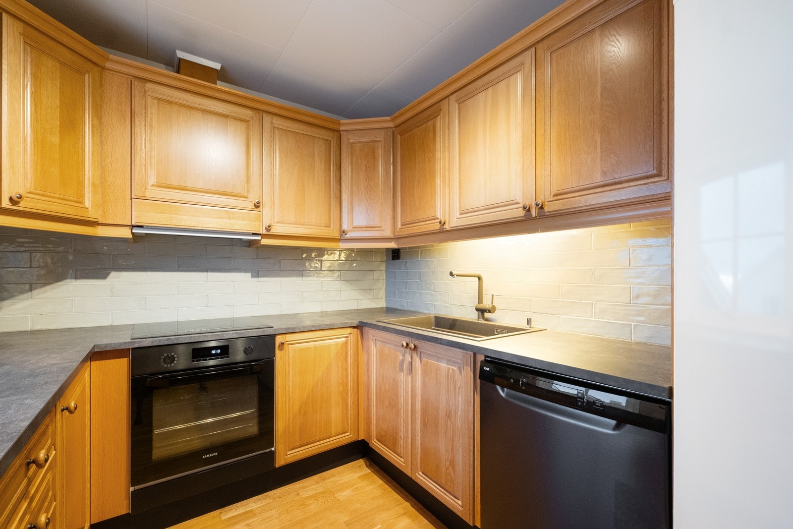 Integrerte hvitevarer og laminat benkeplate gir praktisk arbeidsområde. Galleribilde