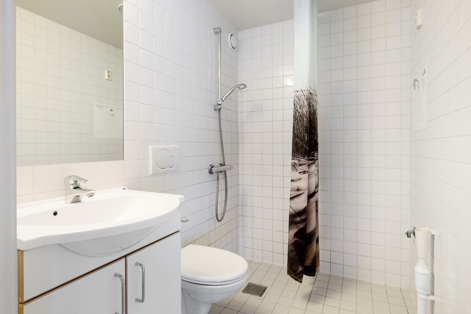 Bad utstyrt med servant, dusj, og toalett - opplegg for vaskemaskin og varmekabler i gulv. Galleribilde