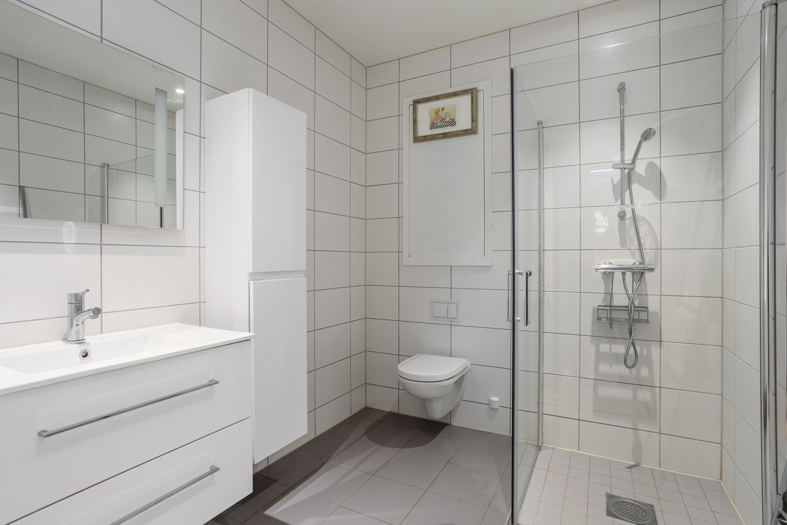 Badet er romslig og har flislagte gulv og vegger. Det er elektriske varmekabler i gulv Galleribilde