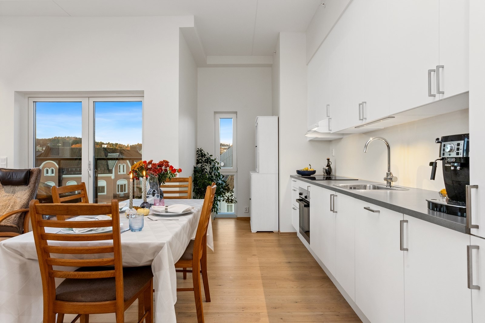 Kjøkkenet har innredning med glatte fronter og benkeplate av laminat Galleribilde