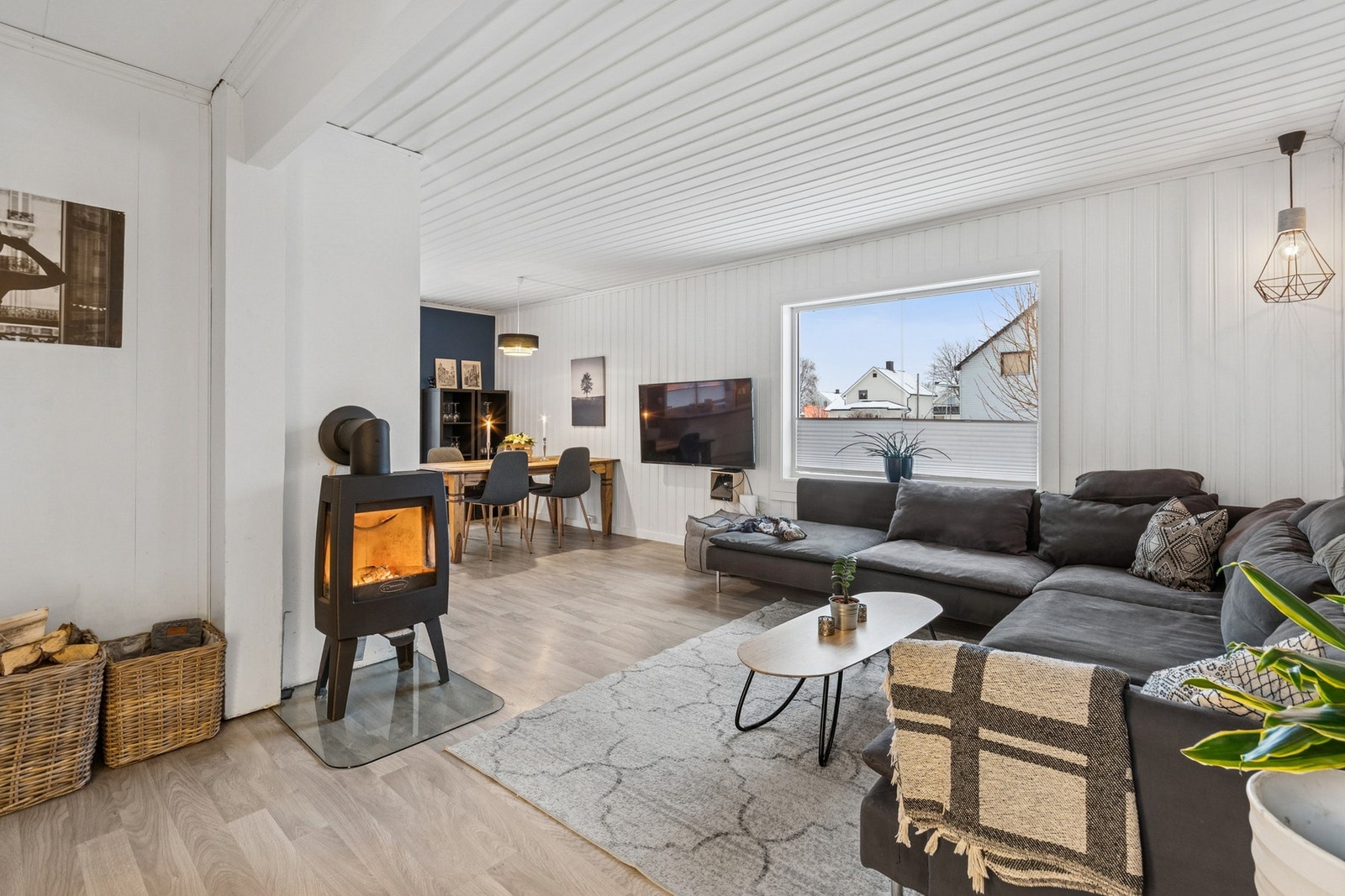 Lys og romslig stue med store vinduer, vedovn og god plass til sofagruppe. Galleribilde