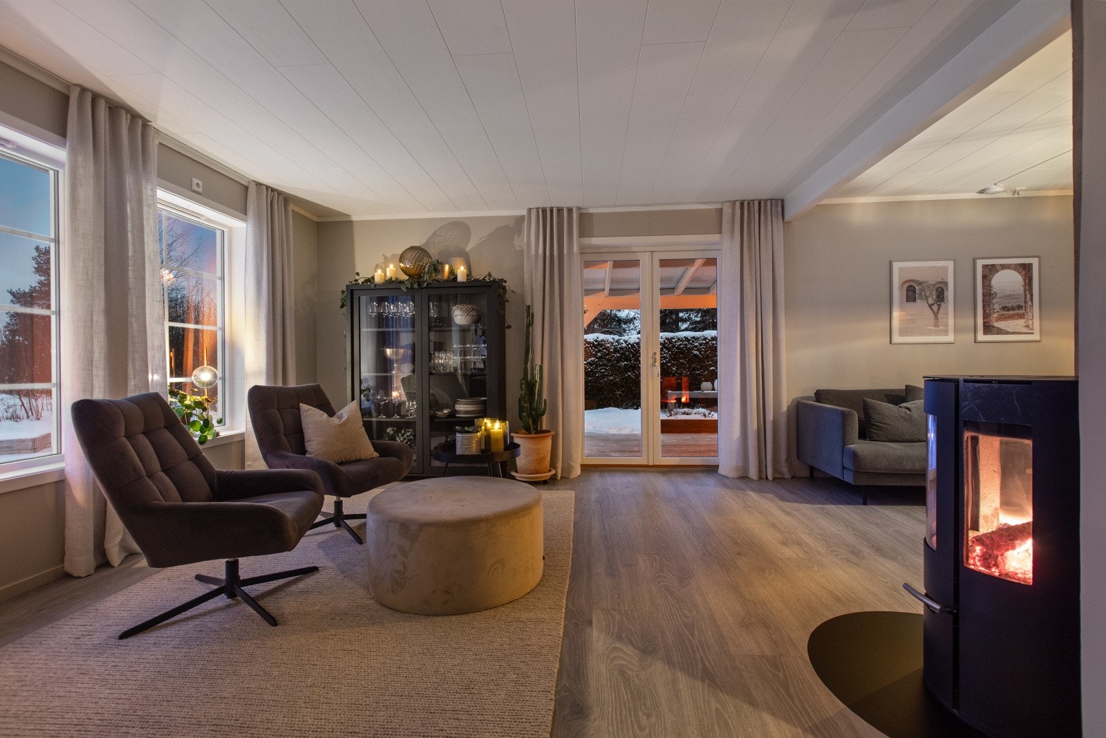 Stuen fremstår like hyggelig på kveldstid som på dagtid, med en varm og innbydende atmosfære. Galleribilde