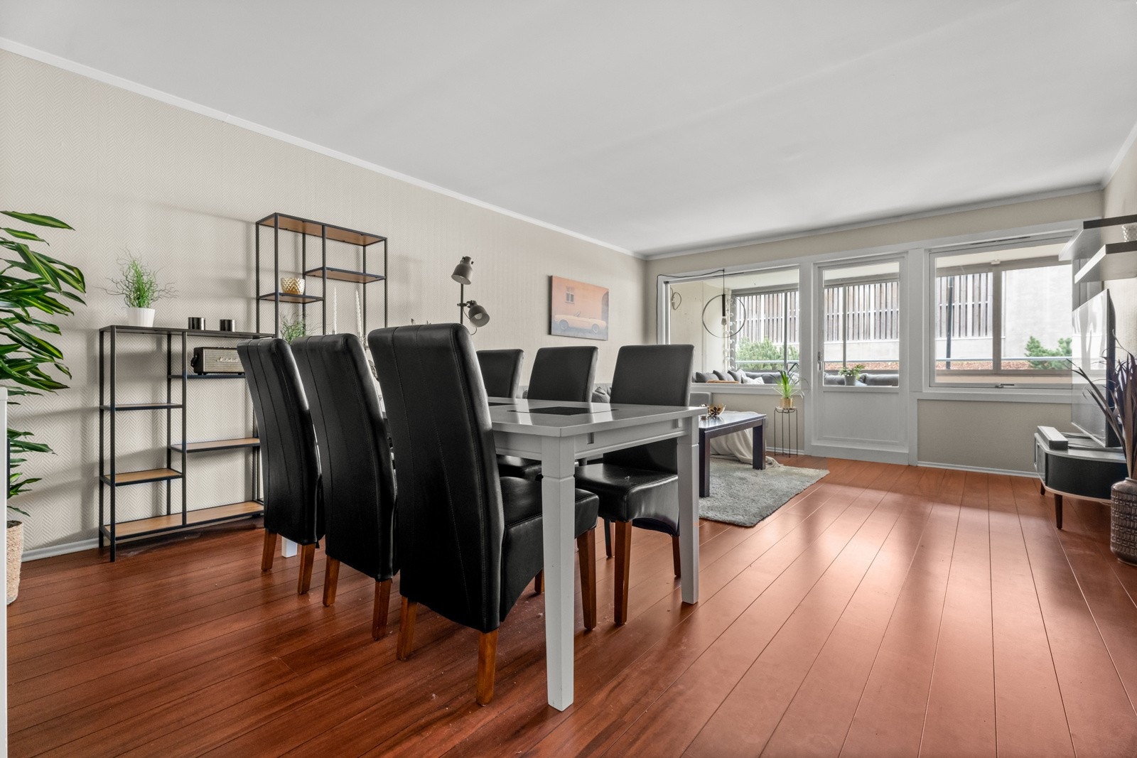 To store vinduer og en glassdør på endeveggen fyller rommet med naturlig lys og utenfor er det innglasset balkong som øker romfølelsen ytterligere. Galleribilde