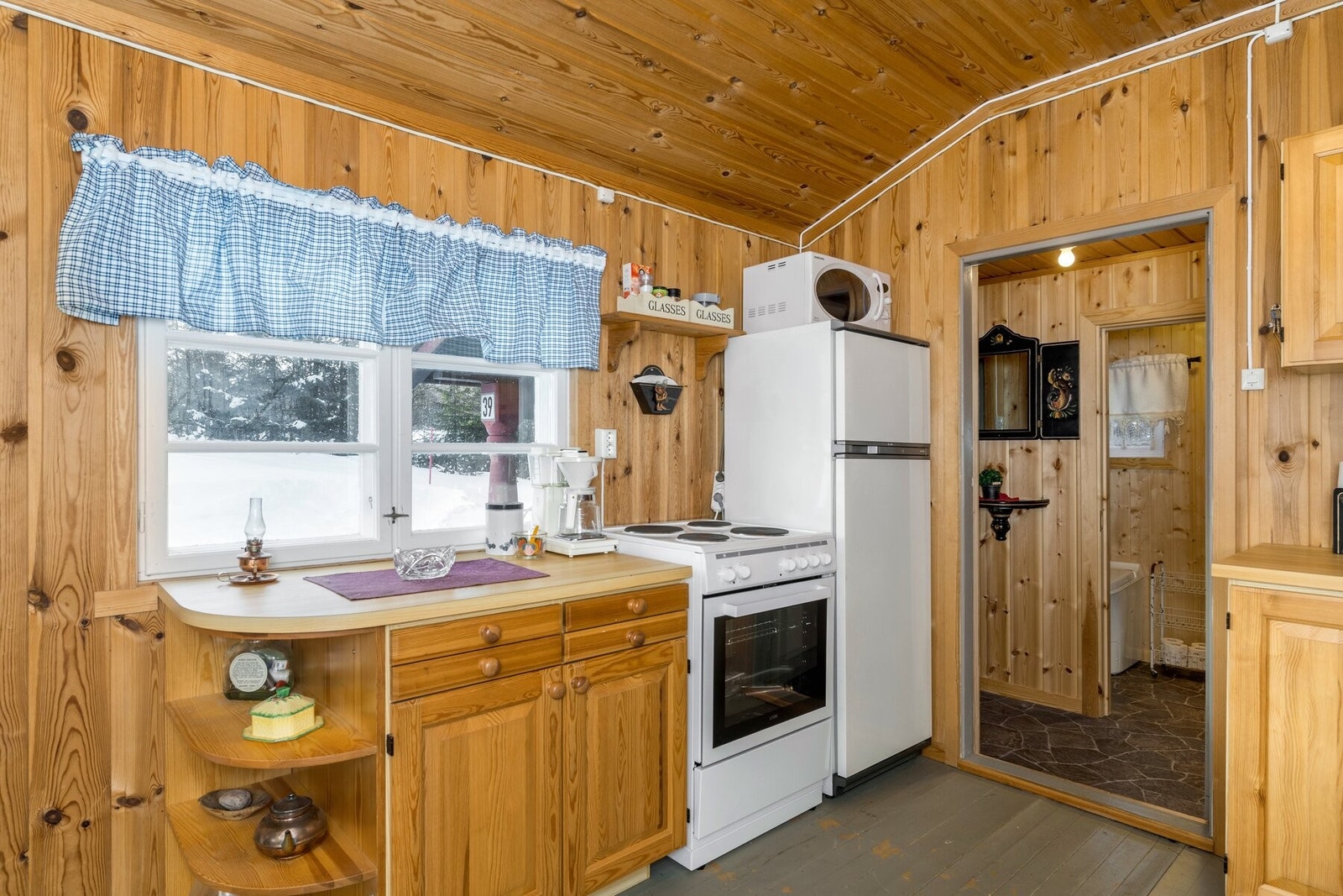 Heltre kjøkkeninnredning med laminat benkeplate, samt frittstående hvitevarer. Galleribilde