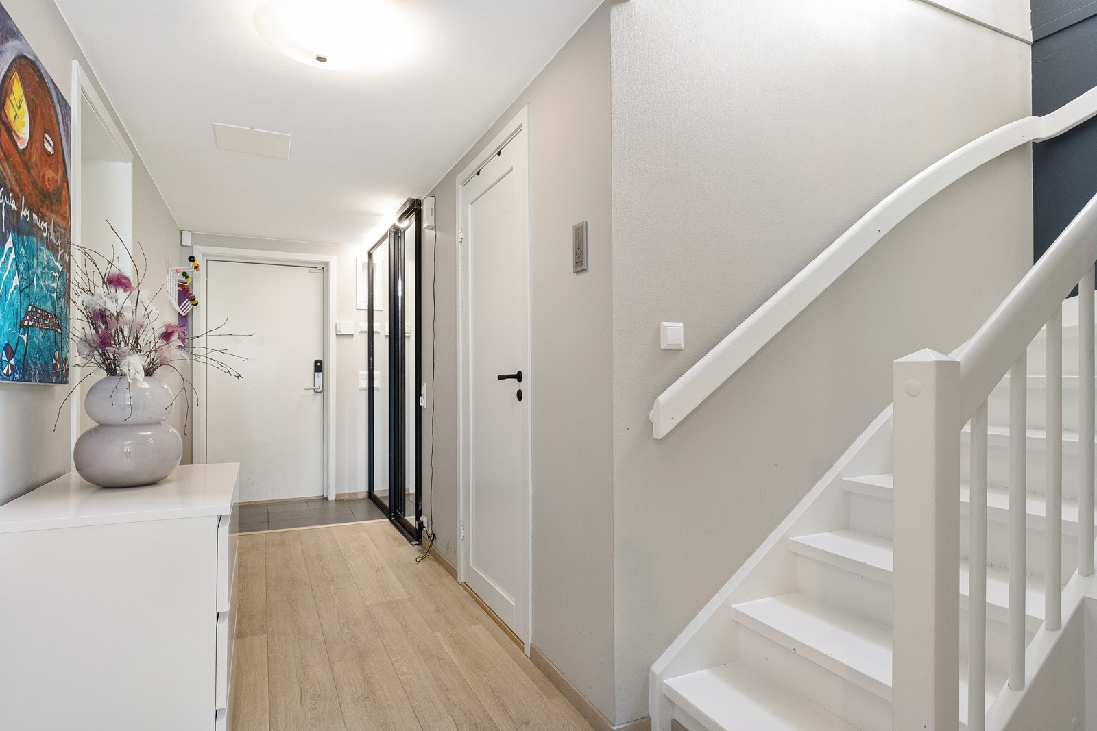 Velkommen inn! Flislagt entré med speilskyvedørsgarderobe. Gang med enstvavs laminat lagt i 2024. Fra gangen er det adkomst til 3 soverom også med enstvavs laminat lagt i 2024 Galleribilde