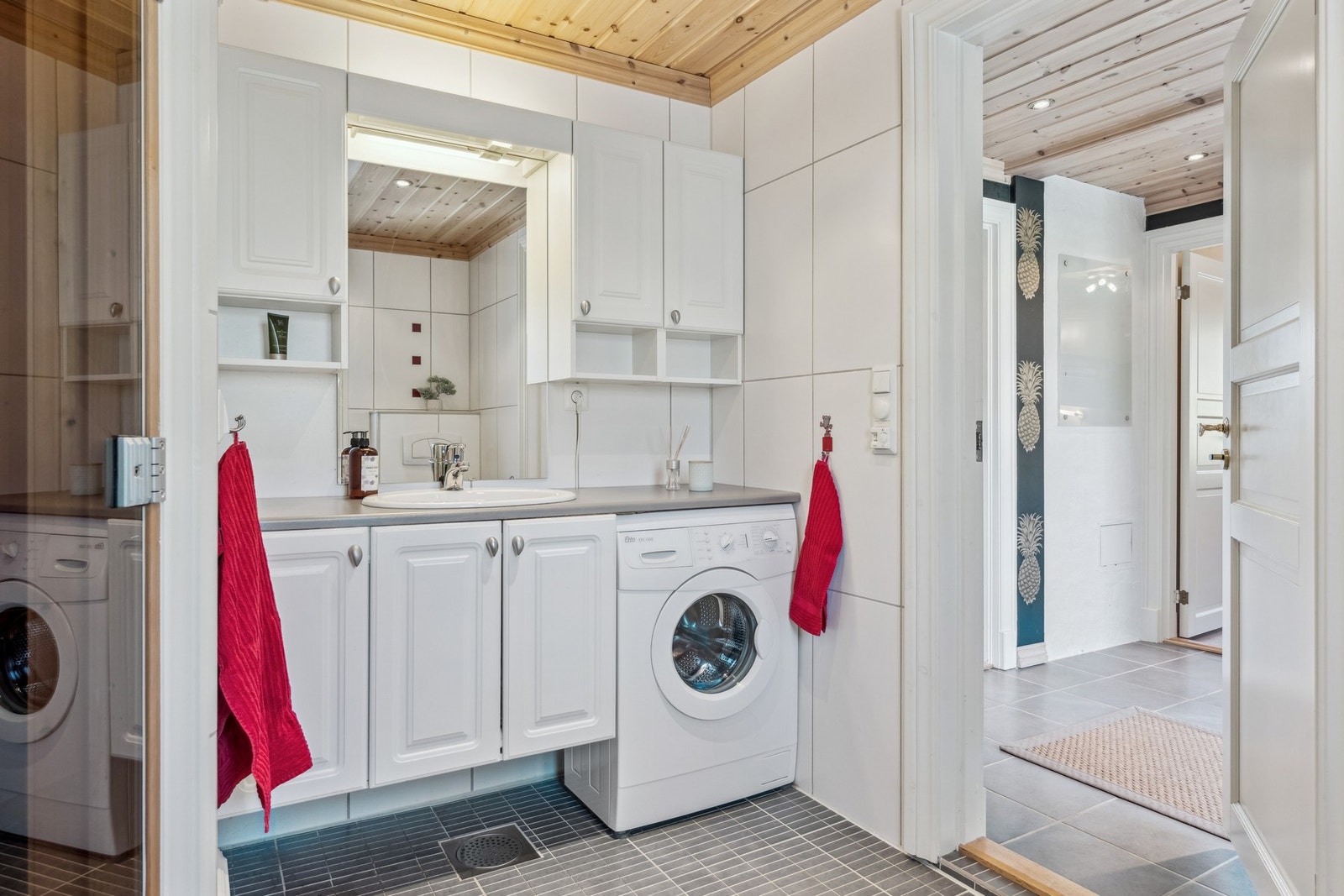 Badet har flislagte overflater, servantinnredning, vegghengt toalett og dusjnisje, samt opplegg for vaskemaskin. Galleribilde