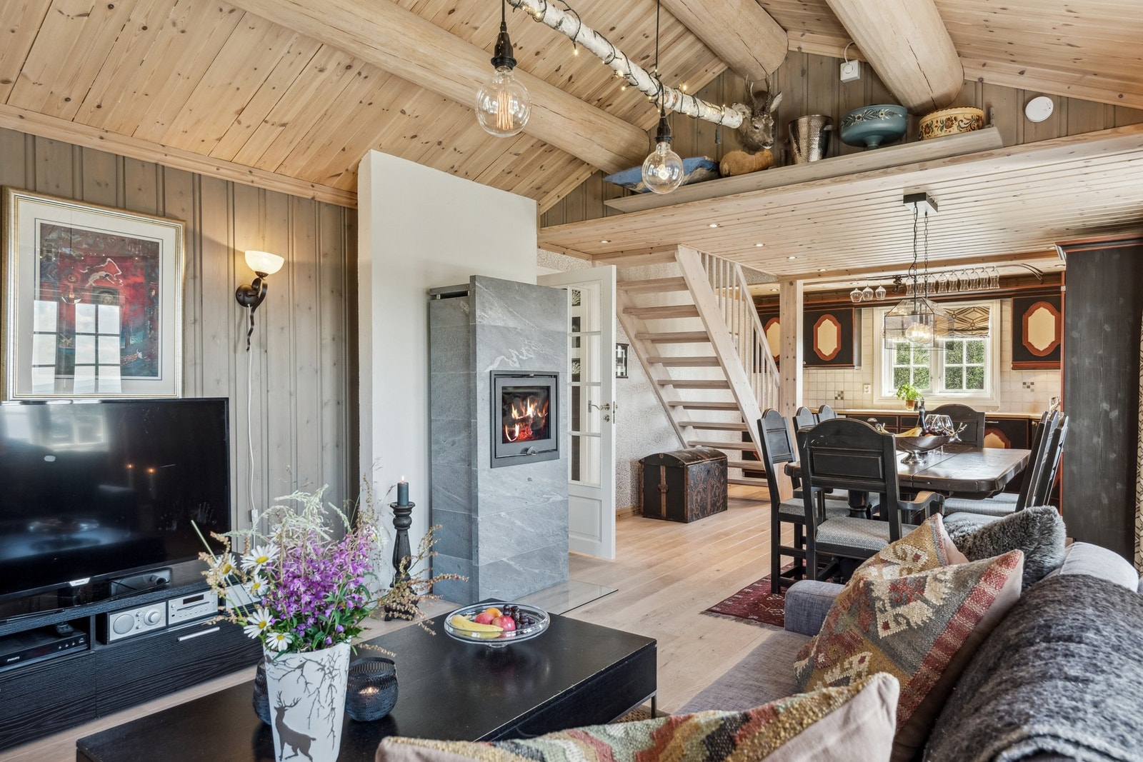 Koselig stue med rausta himling og panelte overflater. Galleribilde