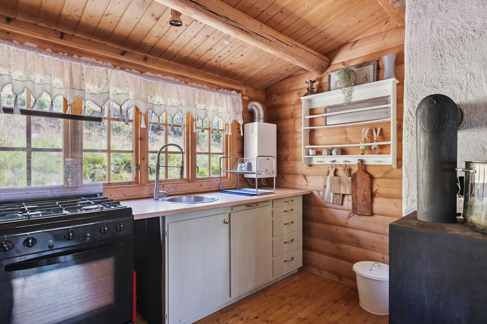 Vegghengt, propandrevet varmtvannsbereder på yttervegg for forsyning av varmt vann til kjøkkenkran. Oppvaskkum med enkelt gråvannsavløp til terreng. Galleribilde