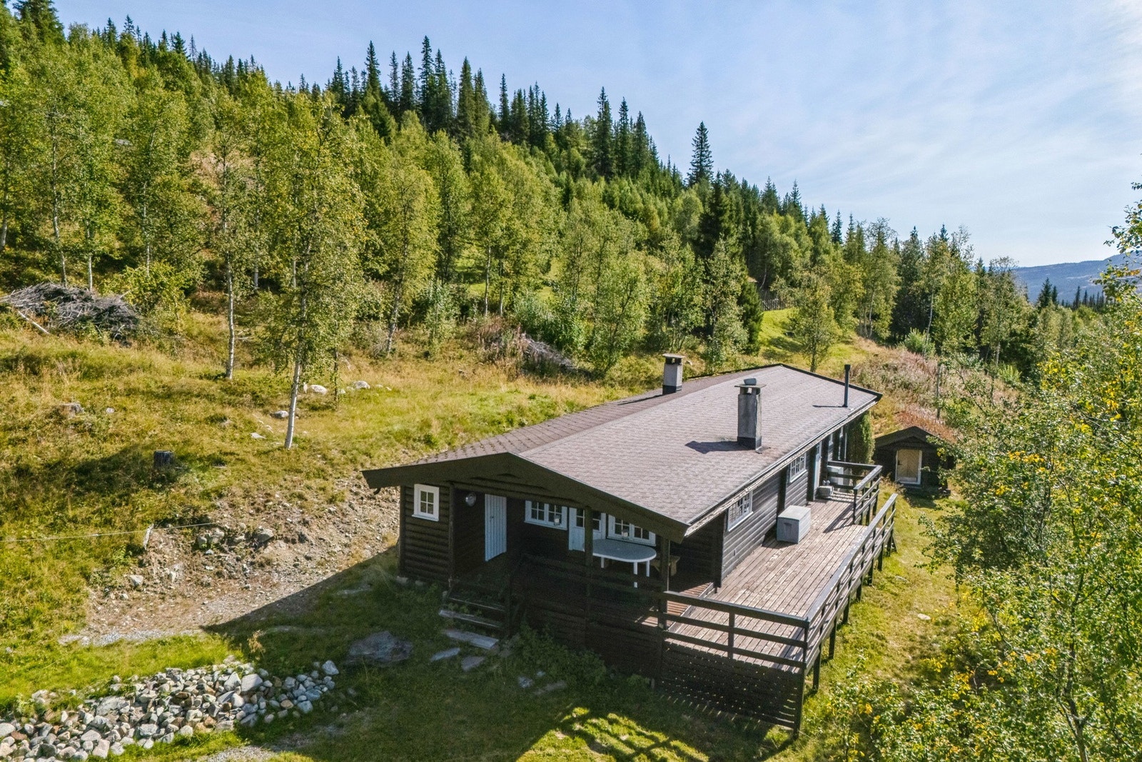 Hytta ligger på hovedsakelig naturtomt, med parkering ved veien og sti opp til hytta. Galleribilde