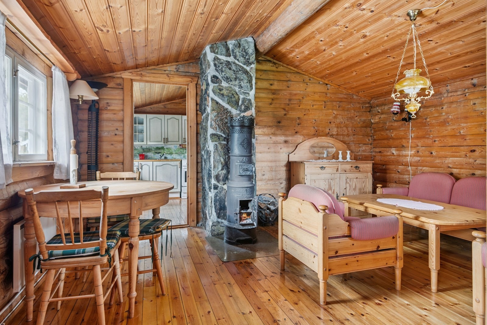 Stuen er hyttas samlingspunkt, med synlige tømmervegger som skaper en lun atmosfære. Galleribilde