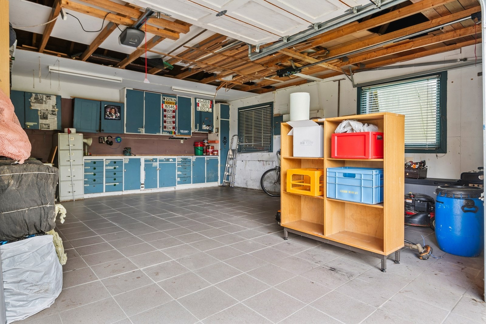 Den doble garasjen har flislagt gulv og rikelig med plass for oppbevaring og hobbyaktiviteter. Galleribilde