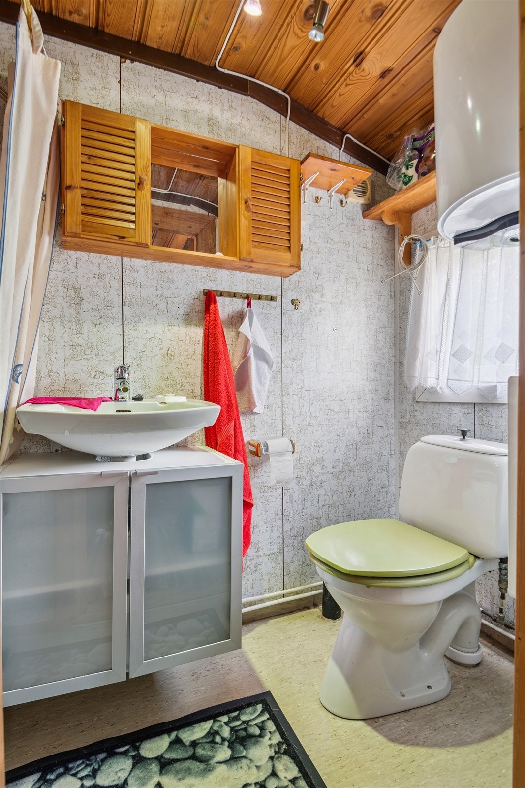 Badet er utstyrt med gulvmontert toalett, servant og dusjløsning. Galleribilde