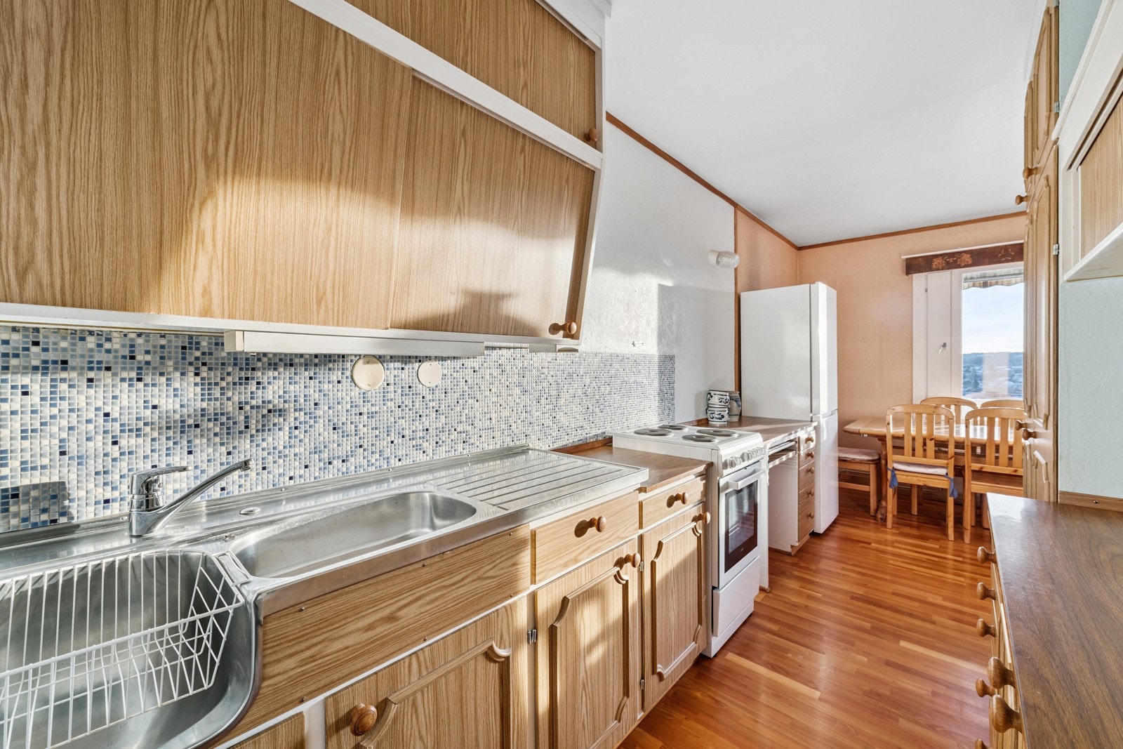 Kjøkken ned åpent til spiseplass og vindu ut mot balkongen. Komfyr og kjøleskap vil følge leiligheten. Galleribilde