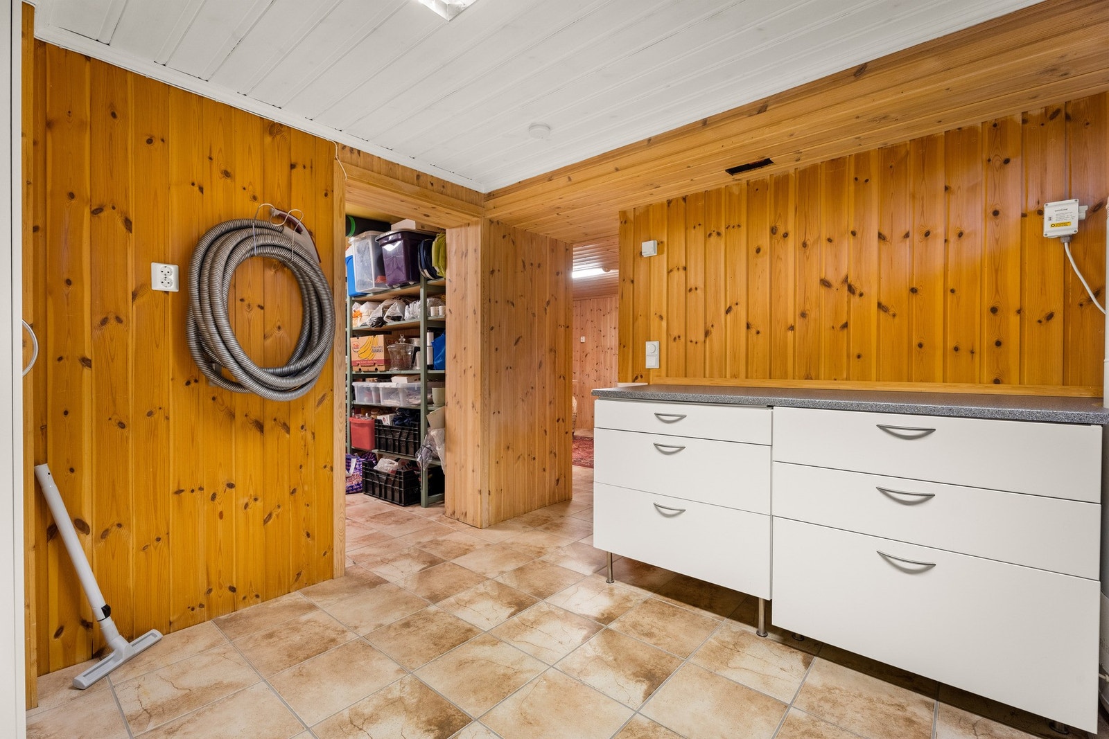 Innredning med slette fronter og profilert benkeplate. Opplegg og plass til vaskemaskin Galleribilde