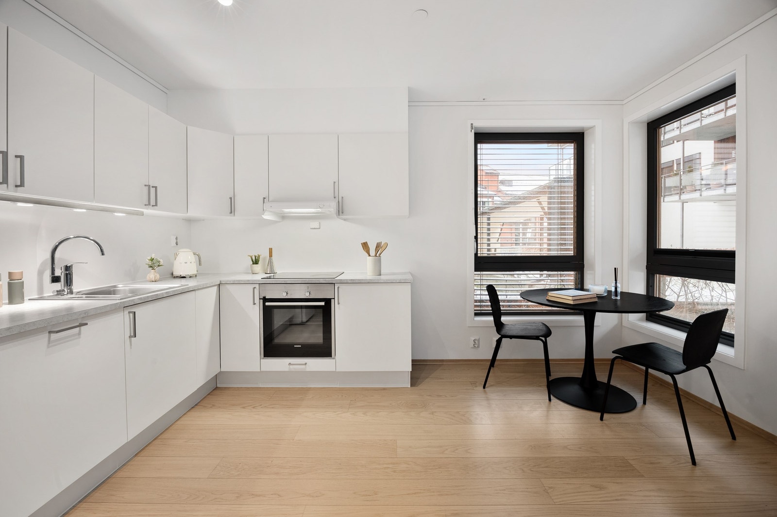 Åpen kjøkken- og stueløsning med sofaområde samt spiseplass Galleribilde