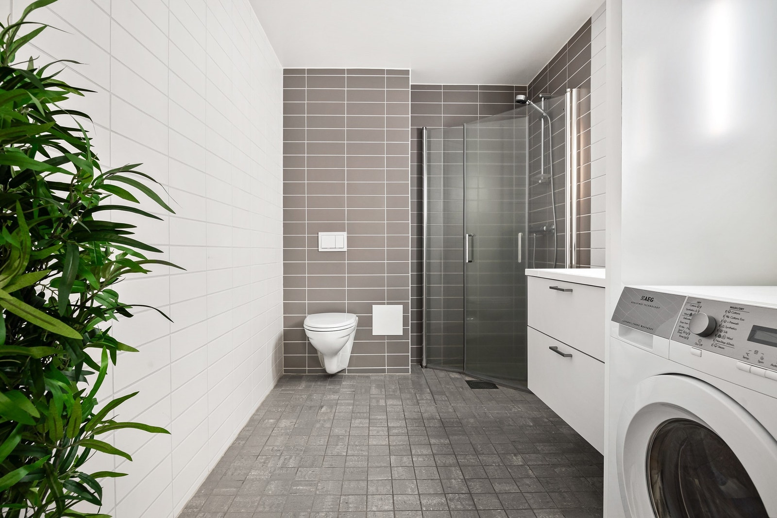 Badet har dusjhjørne med foldedører av glass Galleribilde